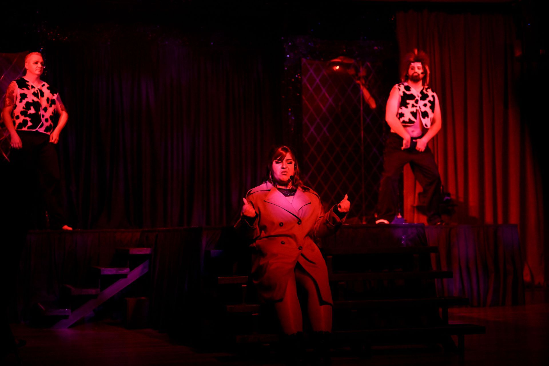 A group of people are dancing on a stage in a dark room— Lux Noir in Townsville City, QLD