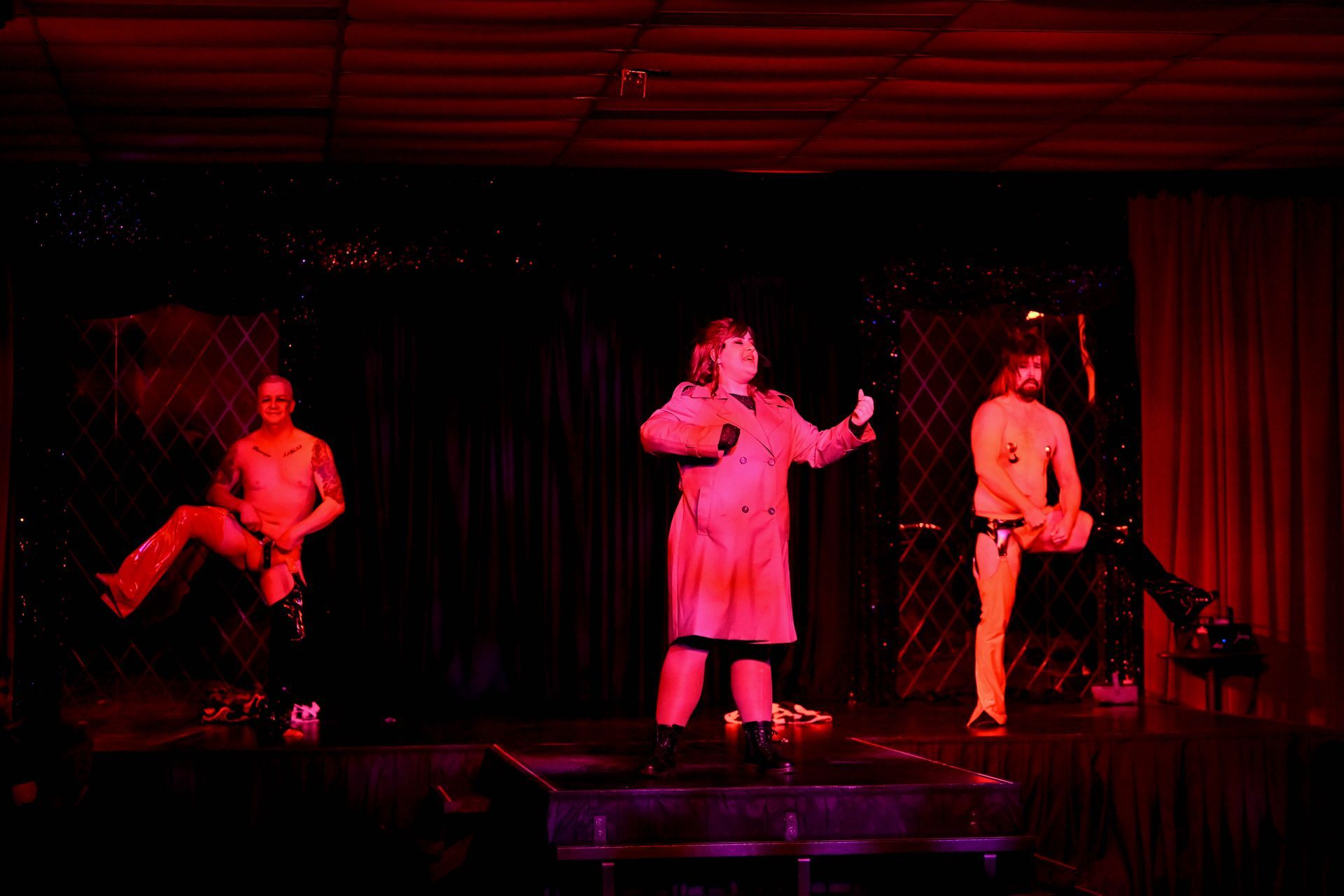 A group of people are standing on a stage in a dark room — Lux Noir in Townsville City, QLD