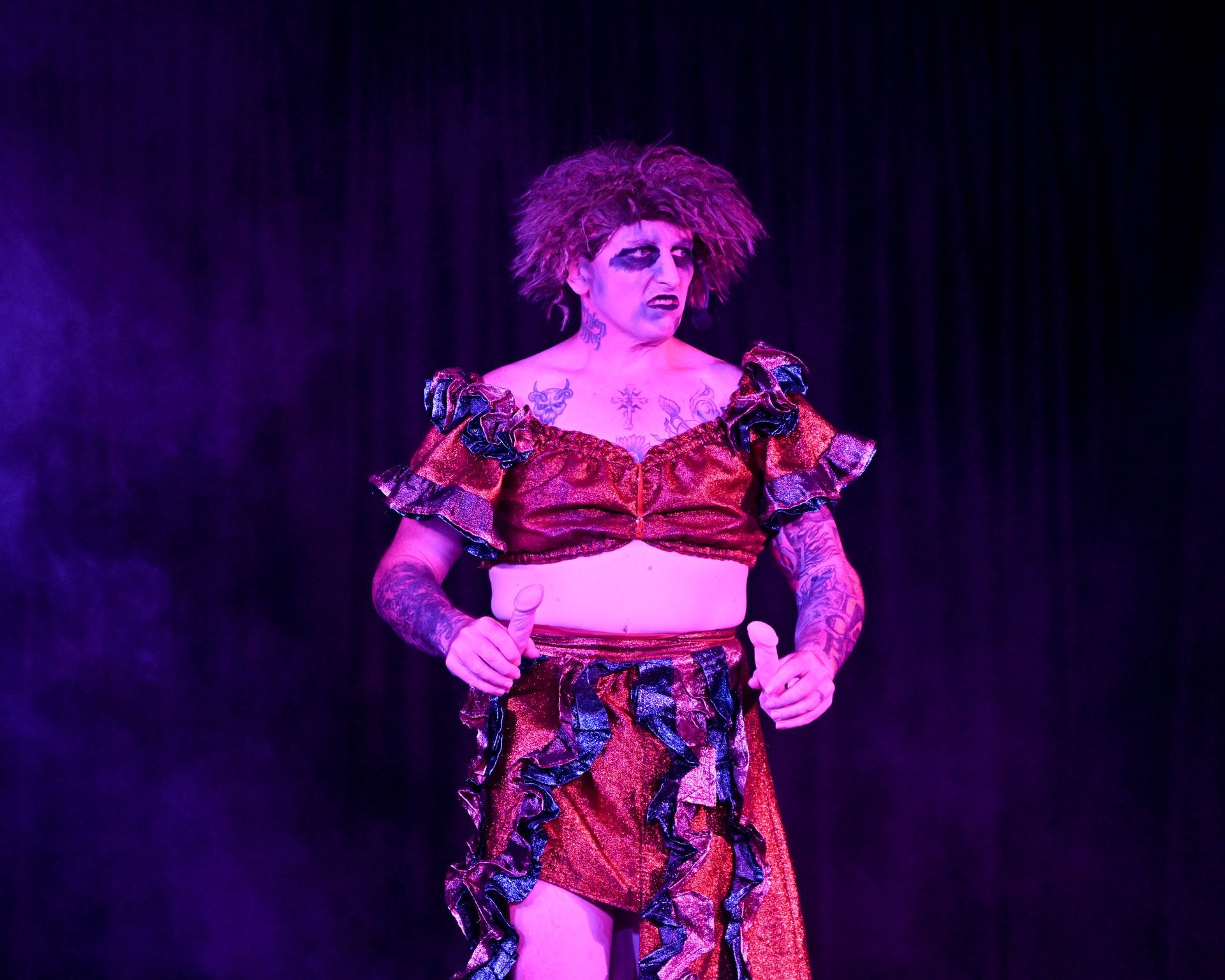 A woman in a purple dress is giving a thumbs up on a stage — Lux Noir in Townsville City, QLD