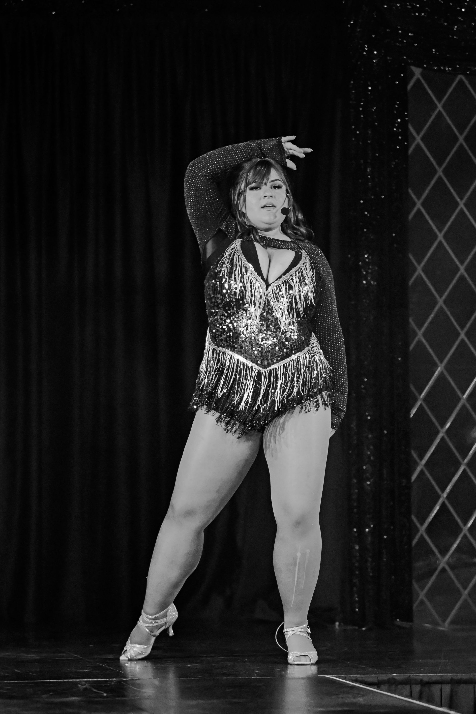 A woman is dancing on a stage in a black and white photo — Lux Noir in Townsville City, QLD