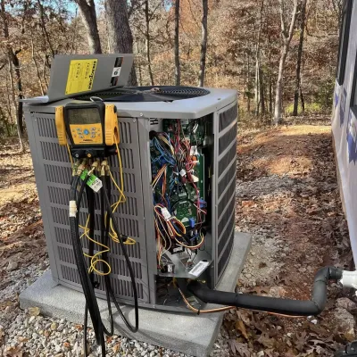 Elite Mechanical Construction LLC - A broken air conditioner is sitting on the ground next to a building.