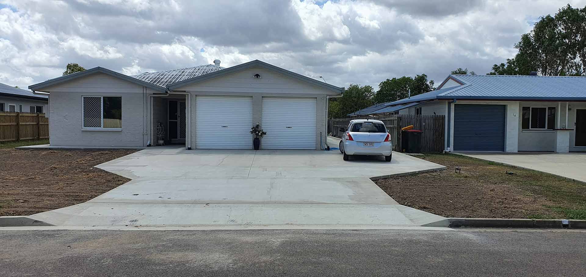 White Car Parked In Front Of A House With Two Garages — Diamond Concreting In Mount Low, QLD