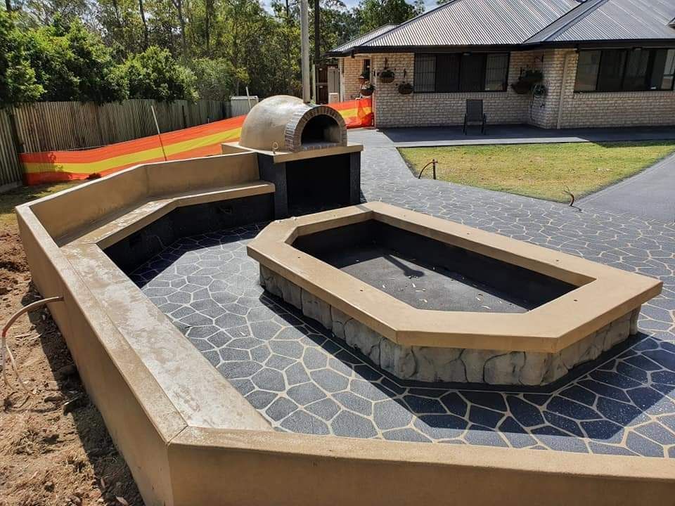 Concrete Patio With A Pizza Oven In The Backyard Of A House — Diamond Concreting In Mount Low, QLD
