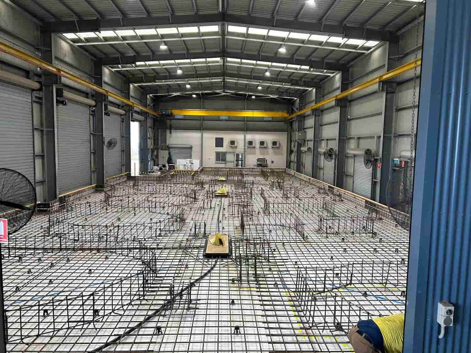 A Large Warehouse With a Lot of Steel Bars on the Floor — Diamond Concreting In Mount Low, QLD