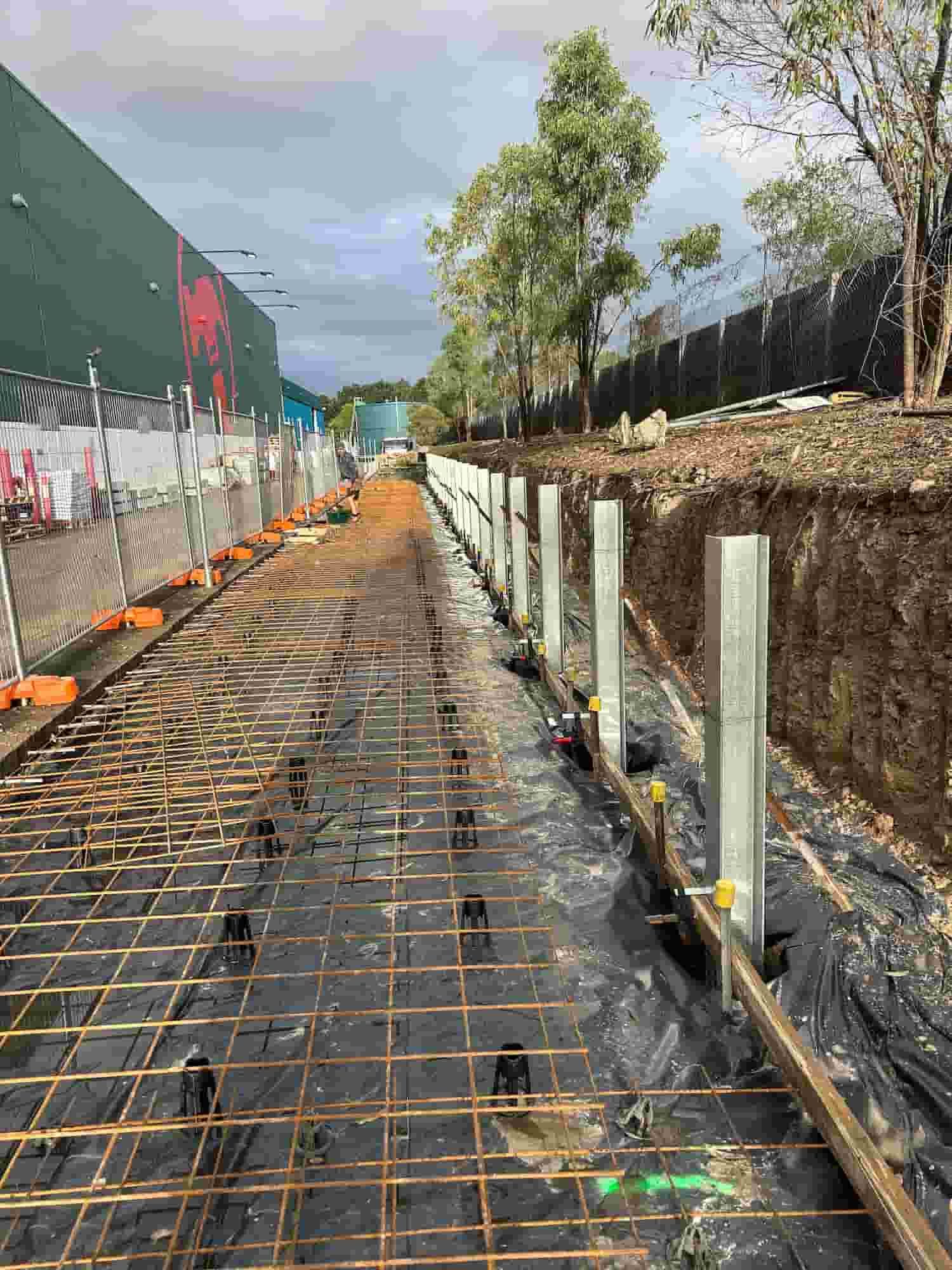 A Concrete Walkway is Being Built Next to a Fence — Diamond Concreting In Mount Low, QLD