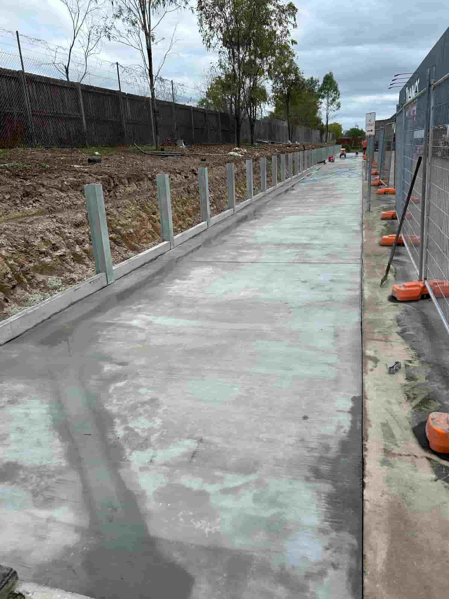 A Concrete Walkway is Being Built Next to a Fence — Diamond Concreting In Mount Low, QLD