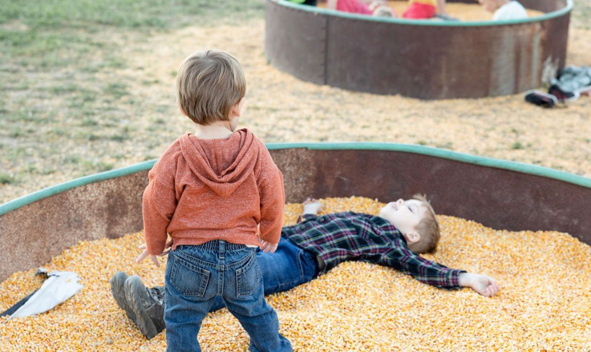 Child exploring straw maze and corn pit near me at fall farm activities Utah