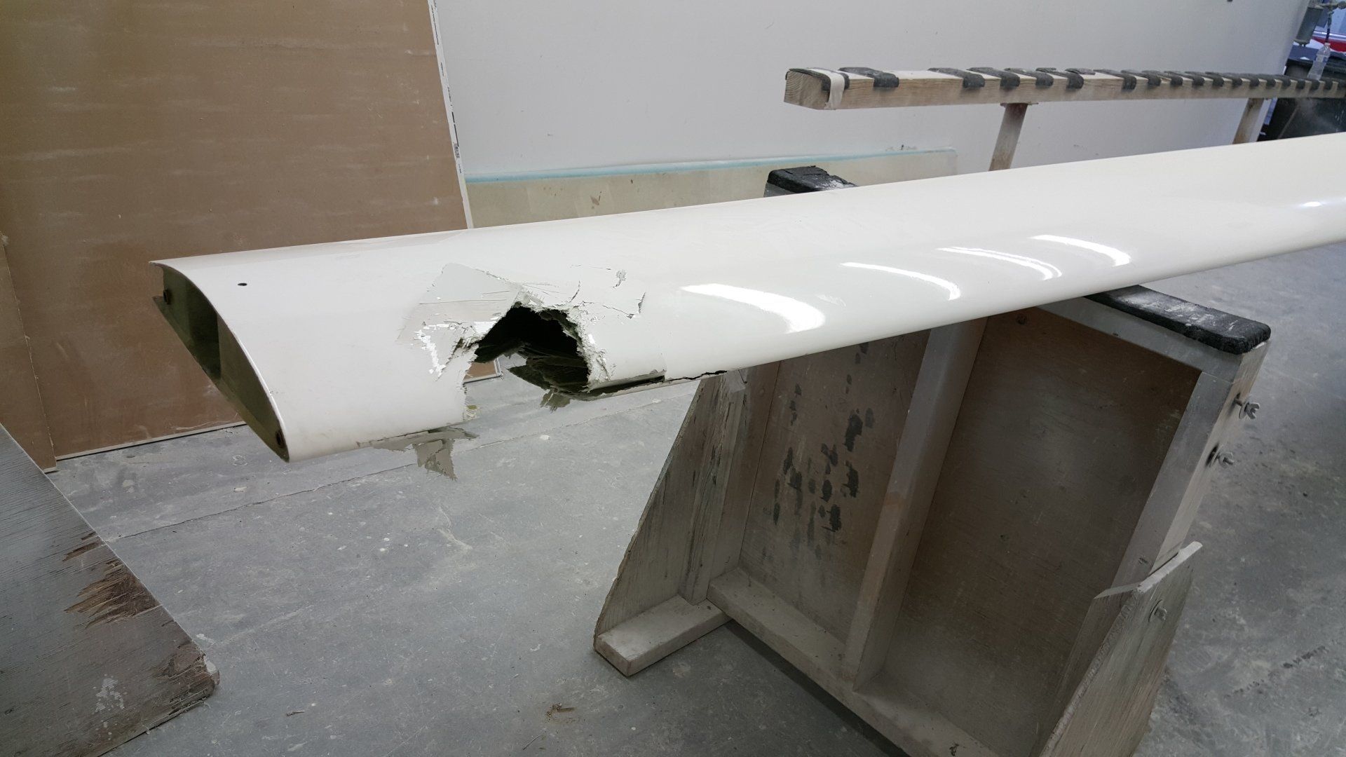 A white pipe with a hole in it is sitting on a wooden table.