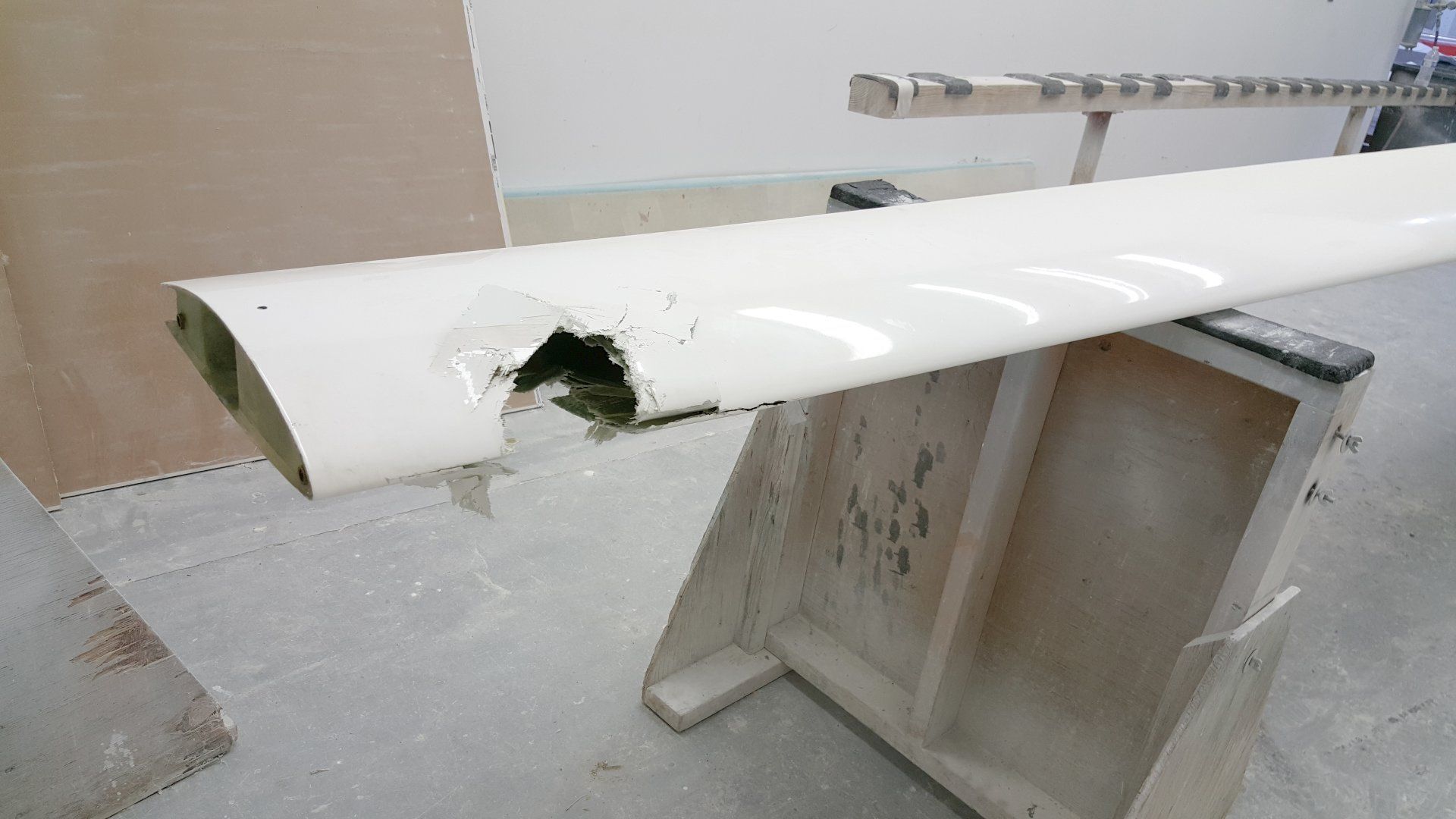 A white pipe with a hole in it is sitting on a wooden table.