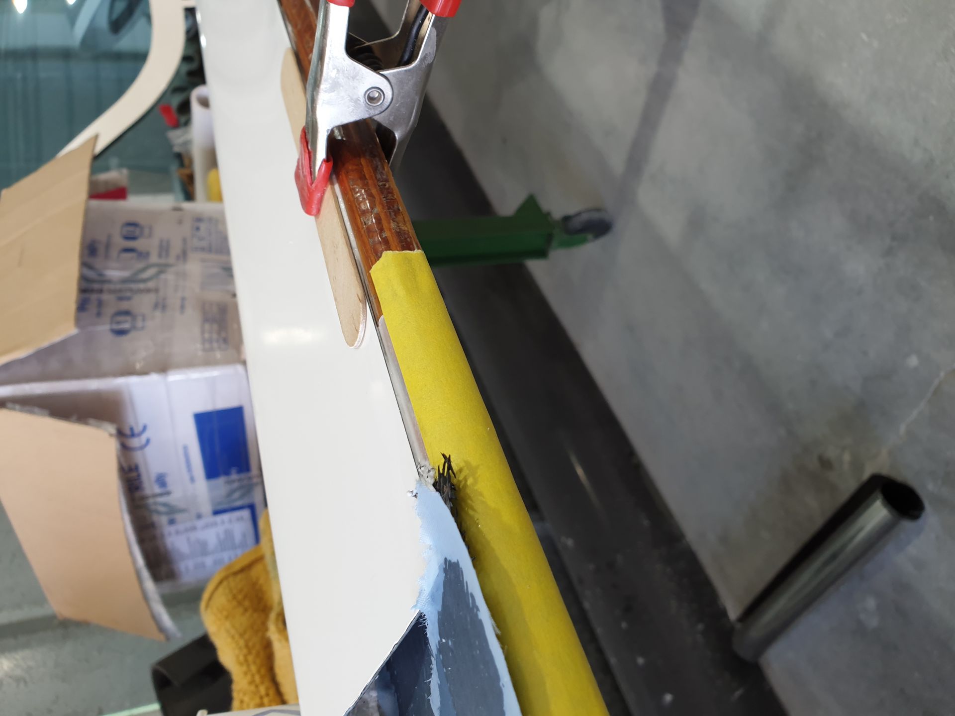 A clamp is holding a piece of cardboard on a table