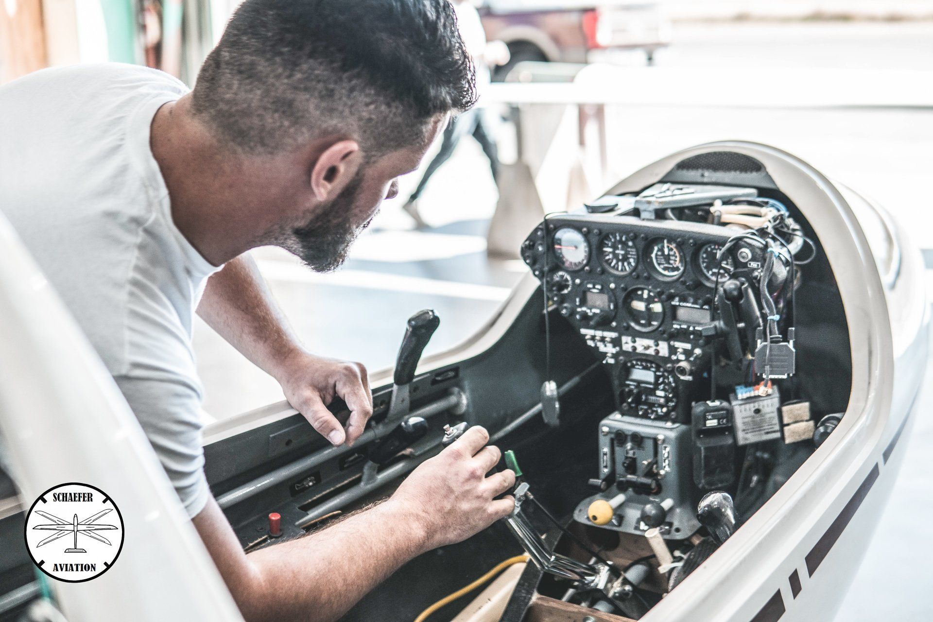 A man is working on the cockpit of an airplane.