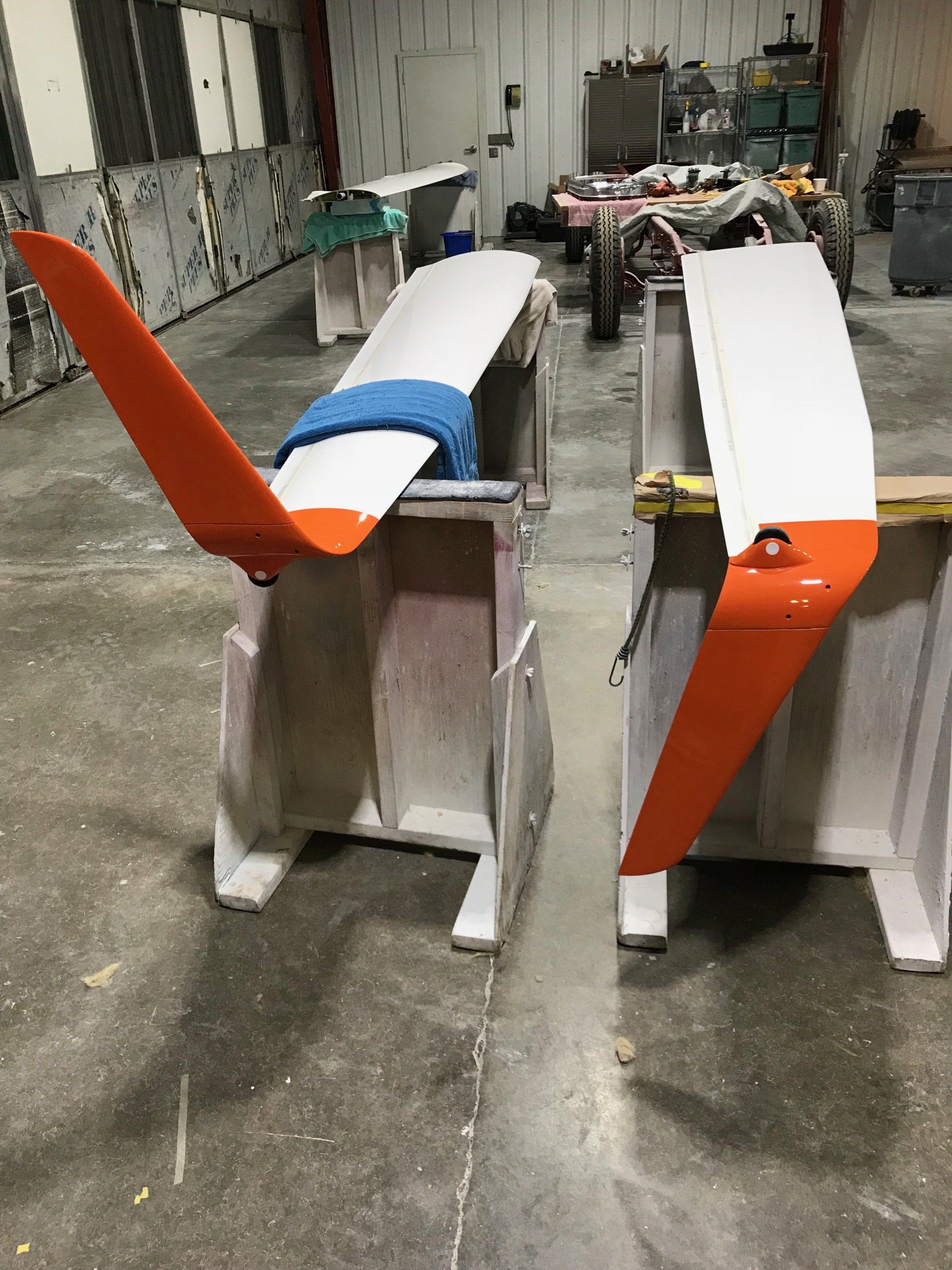 Two pieces of a plane are sitting on a table in a garage.