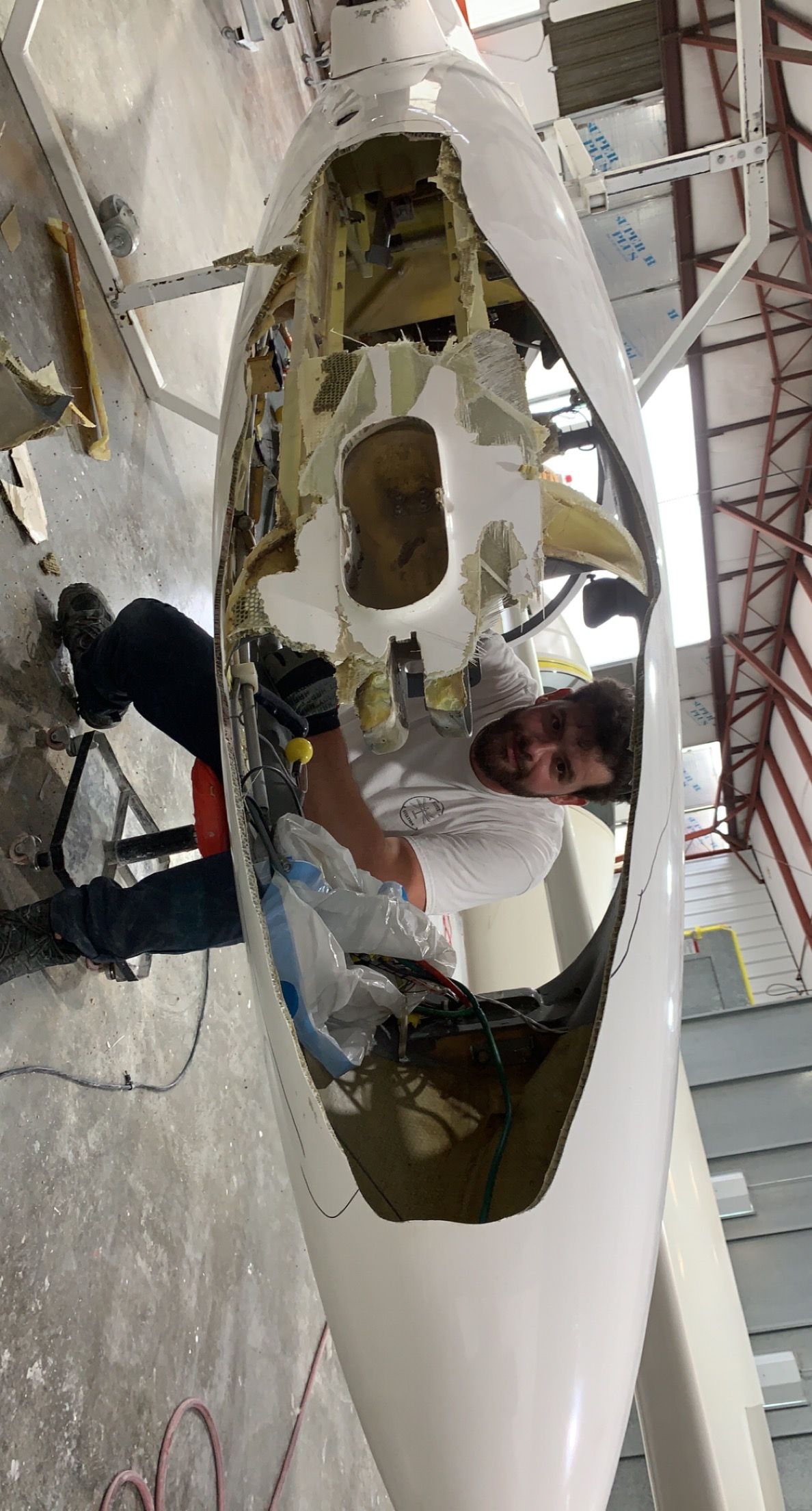 A man is working on a plane in a hangar.