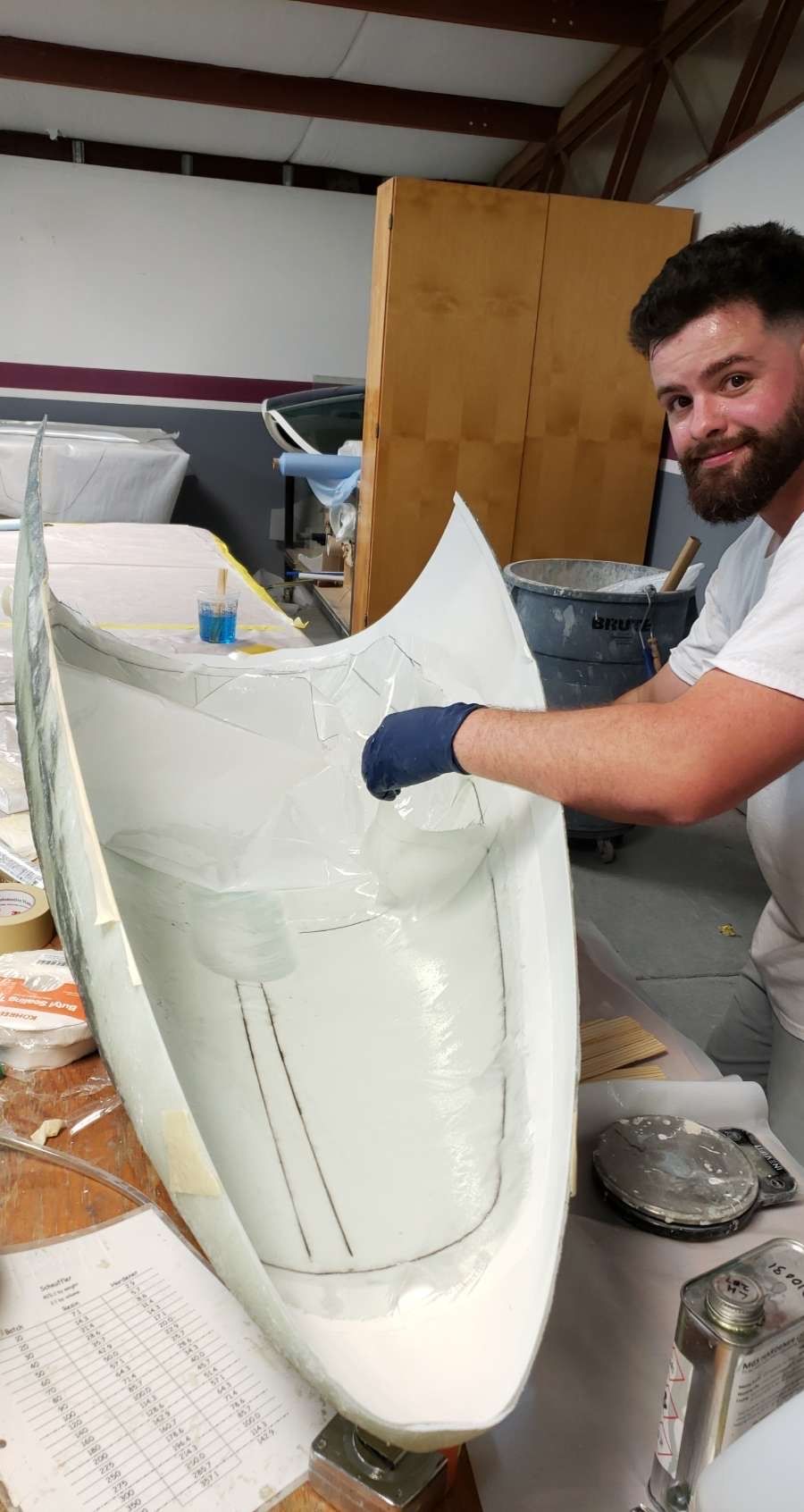 A man is working on a boat in a factory.