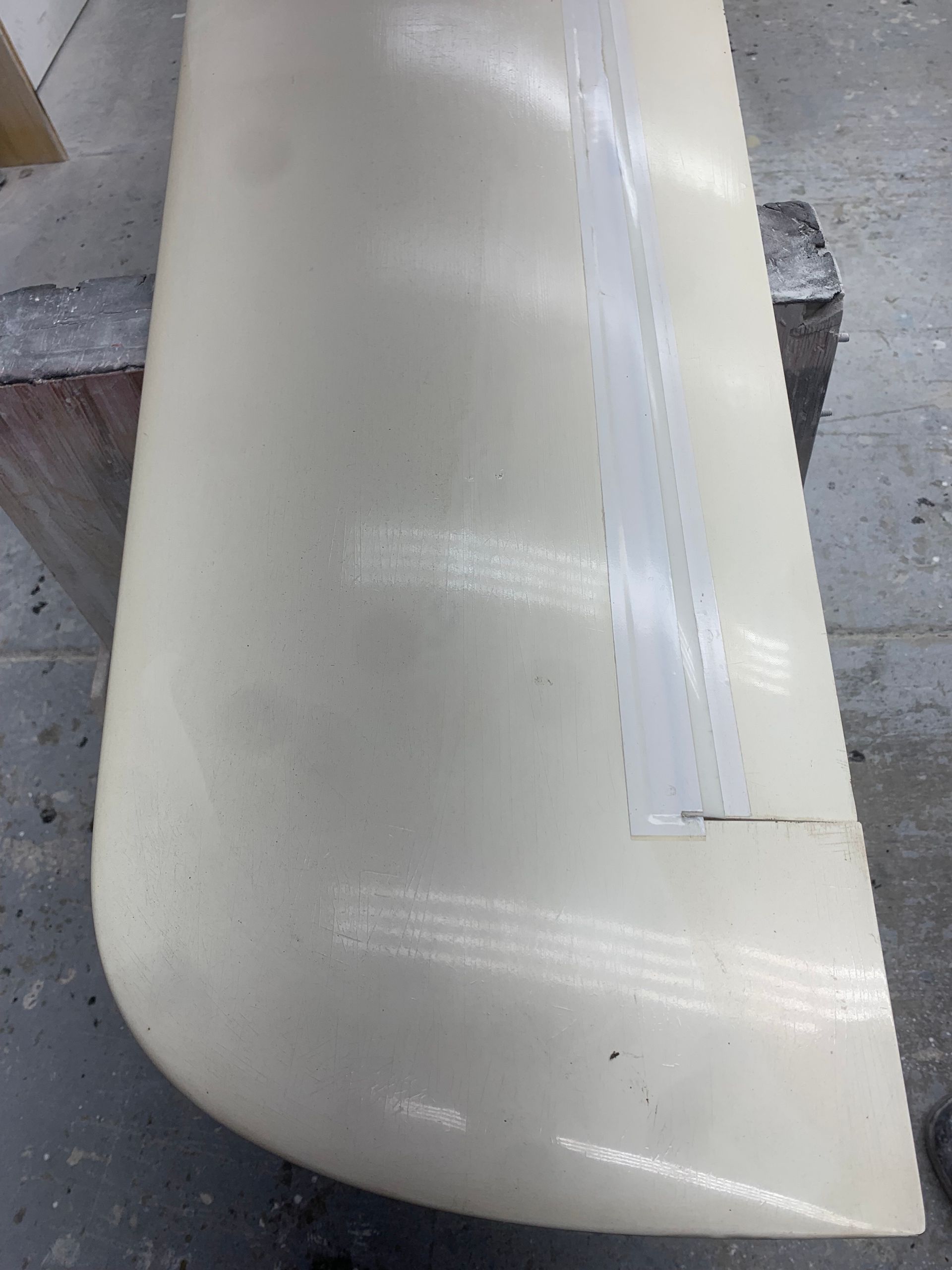 A piece of white plastic is sitting on top of a wooden block.