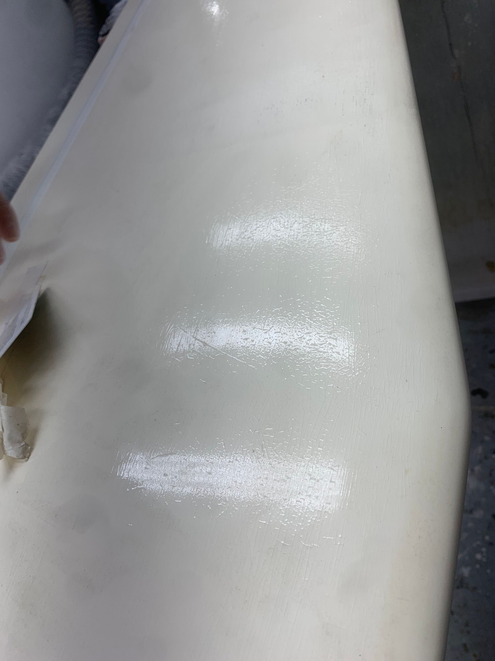 A person is cleaning a white surface with a cloth.