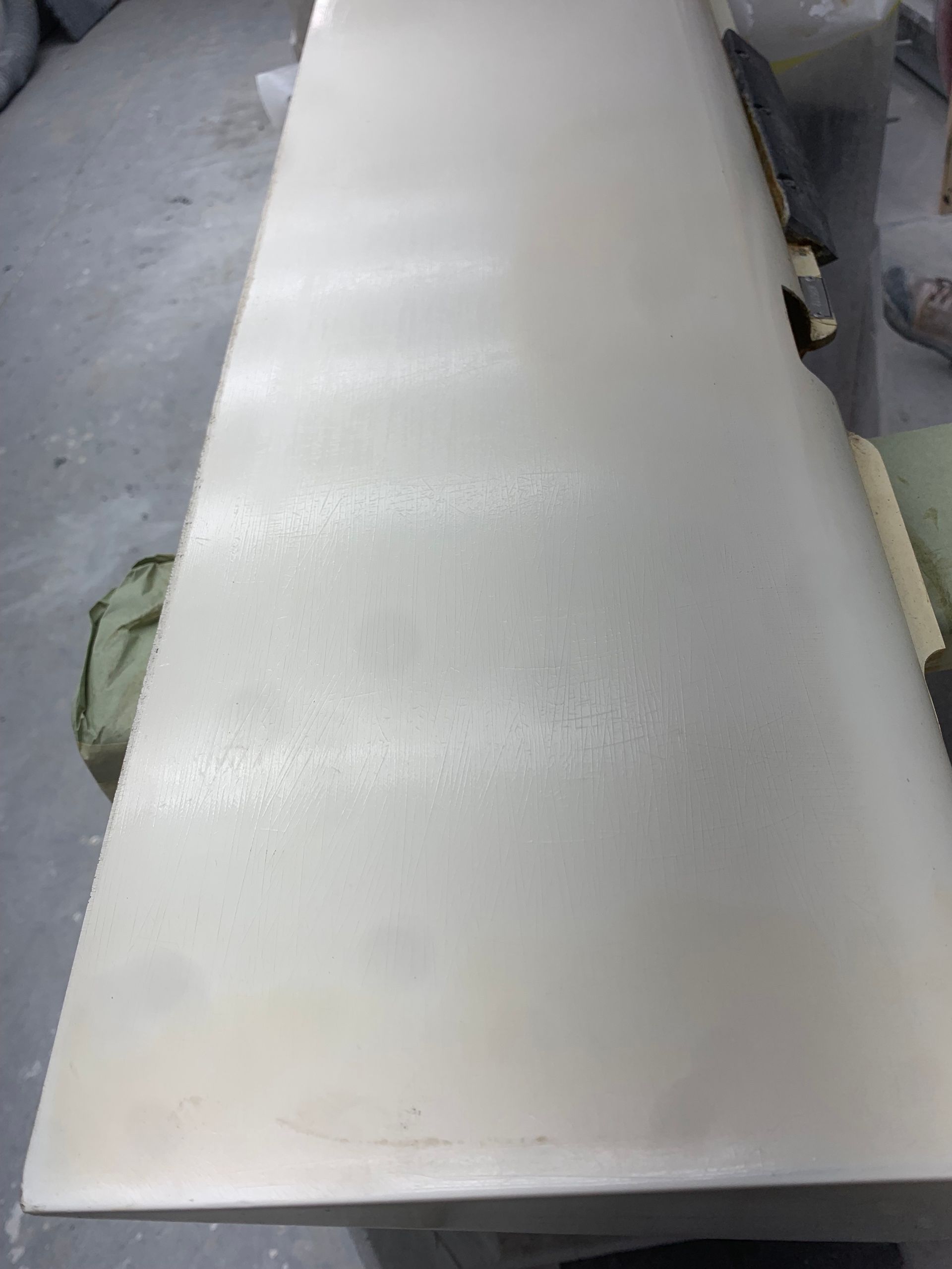 A white table is sitting on a concrete floor in a room.