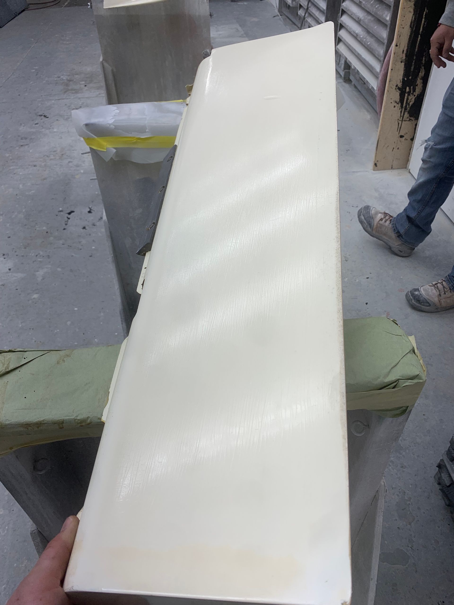 A person is holding a piece of white plastic in their hand.