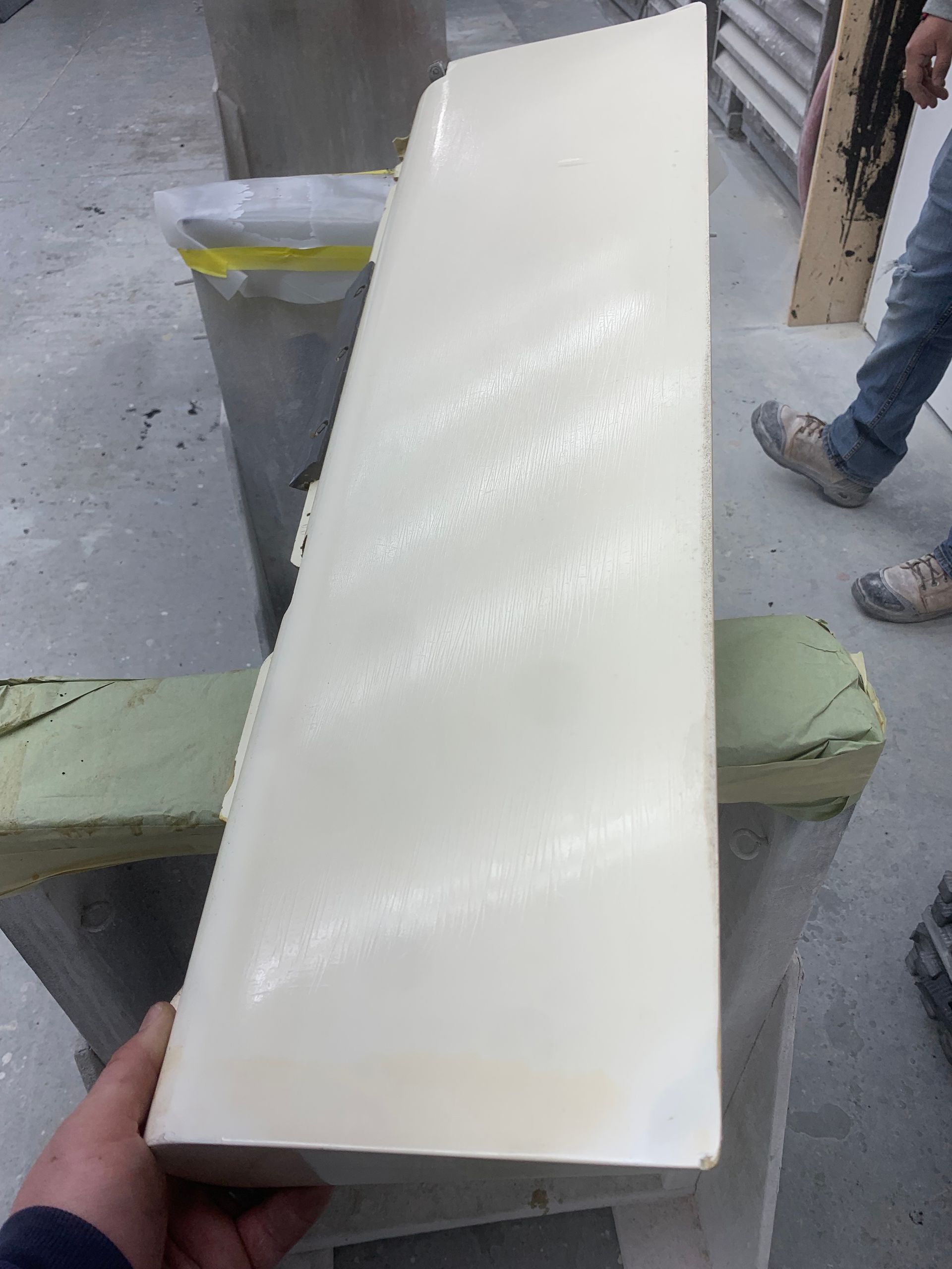 A person is holding a piece of white plastic in their hand.