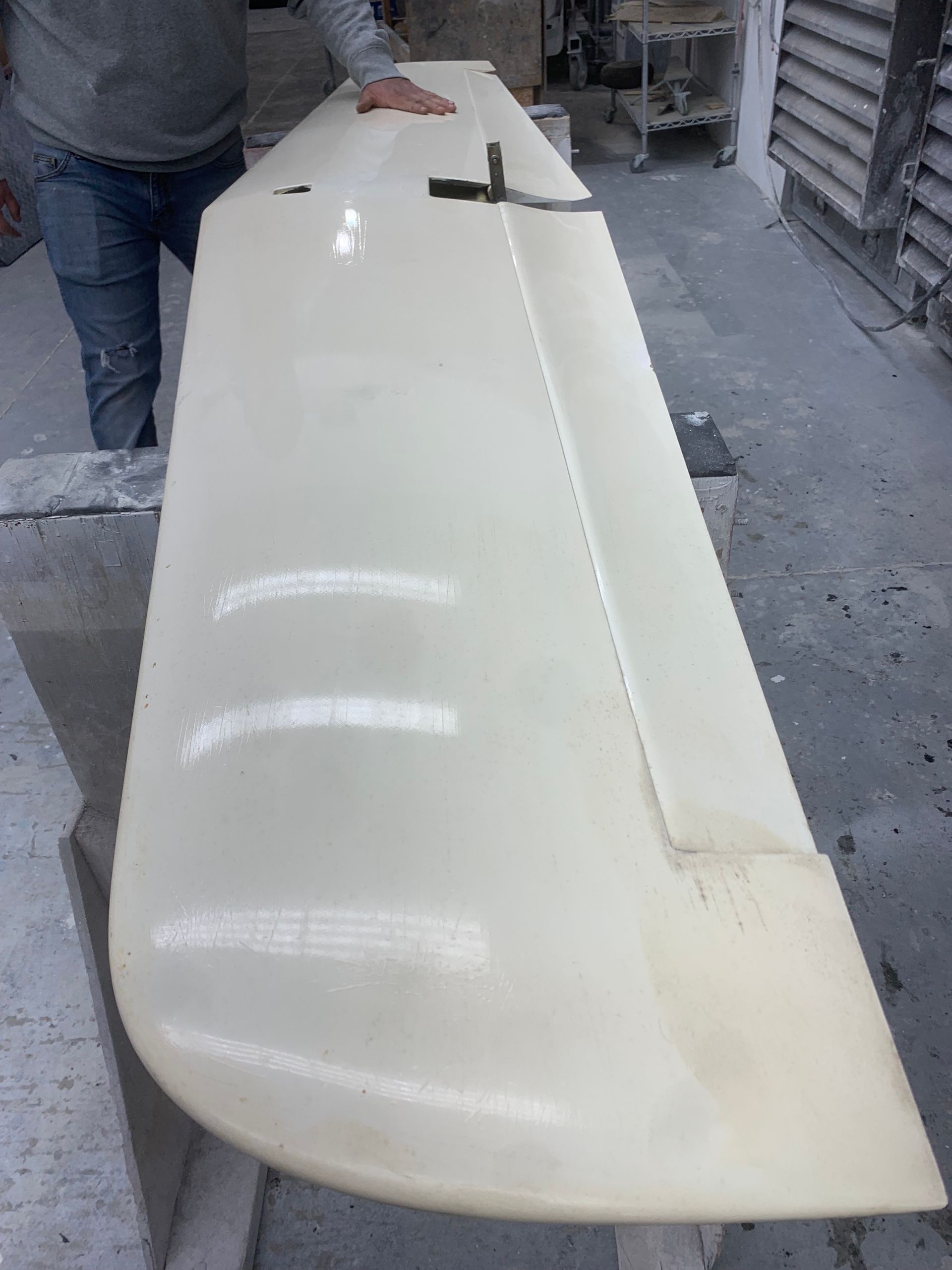 A person is standing next to a large white object.