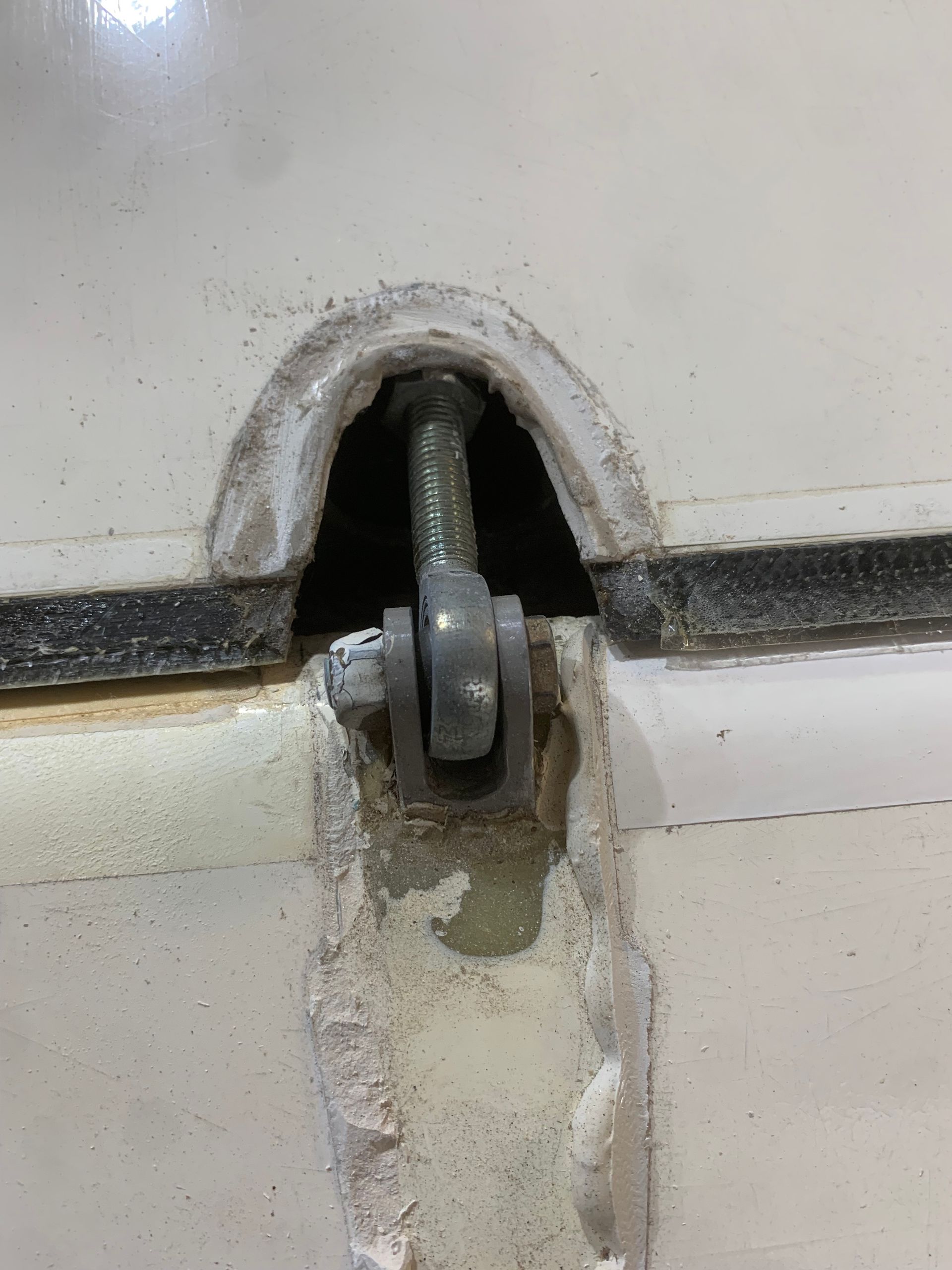 A close up of a screw in a hole in a wall.