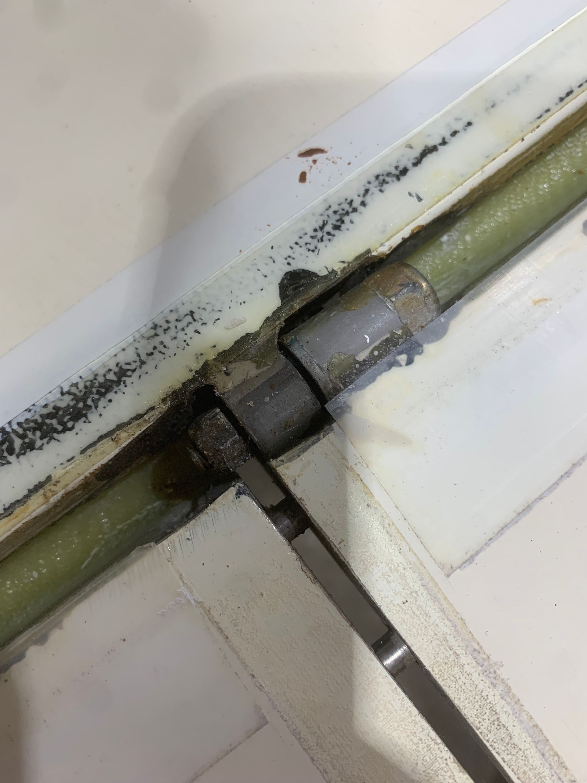 A close up of a door hinge on a white door.