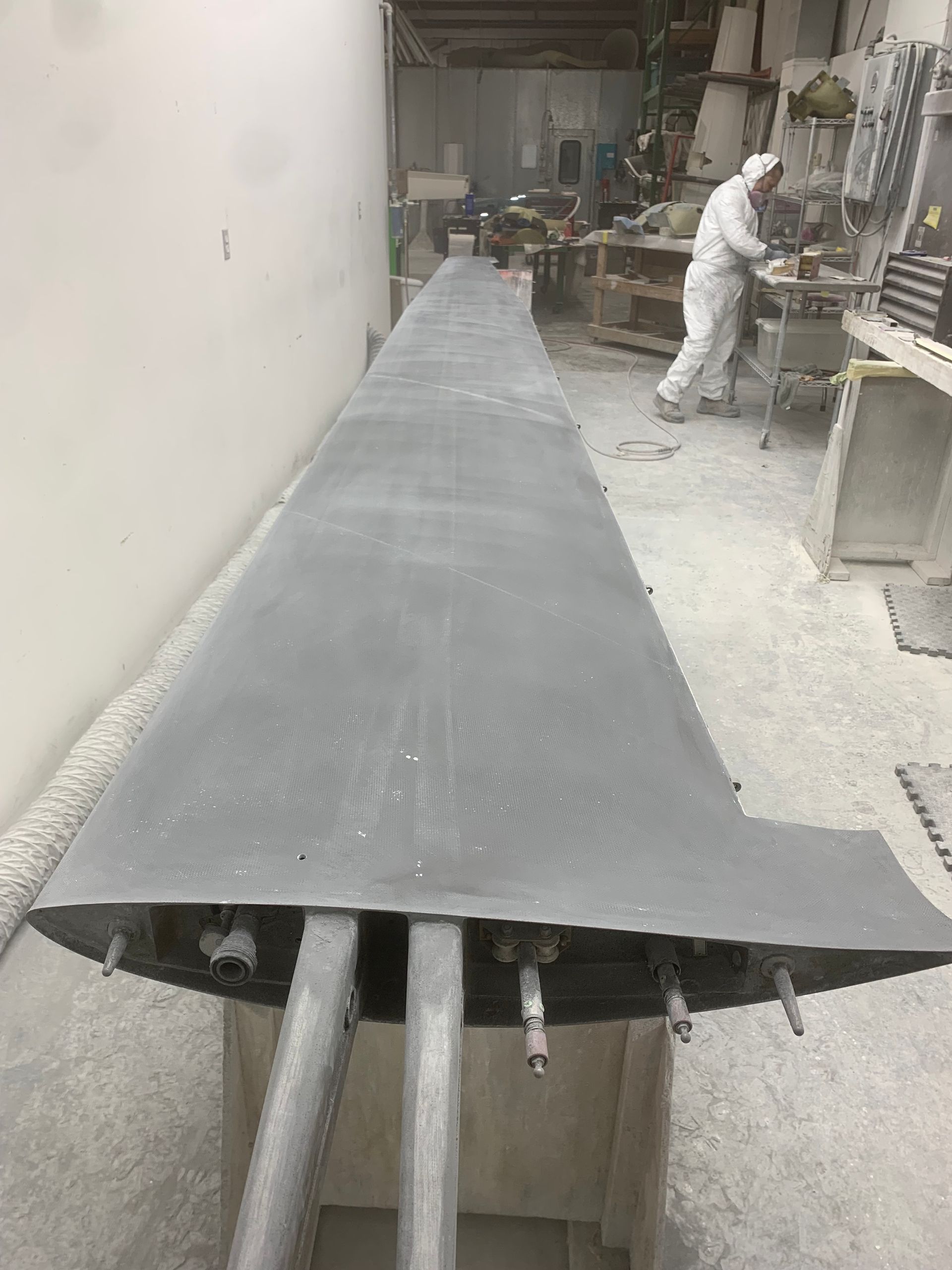 A man is working on a large piece of metal in a factory.