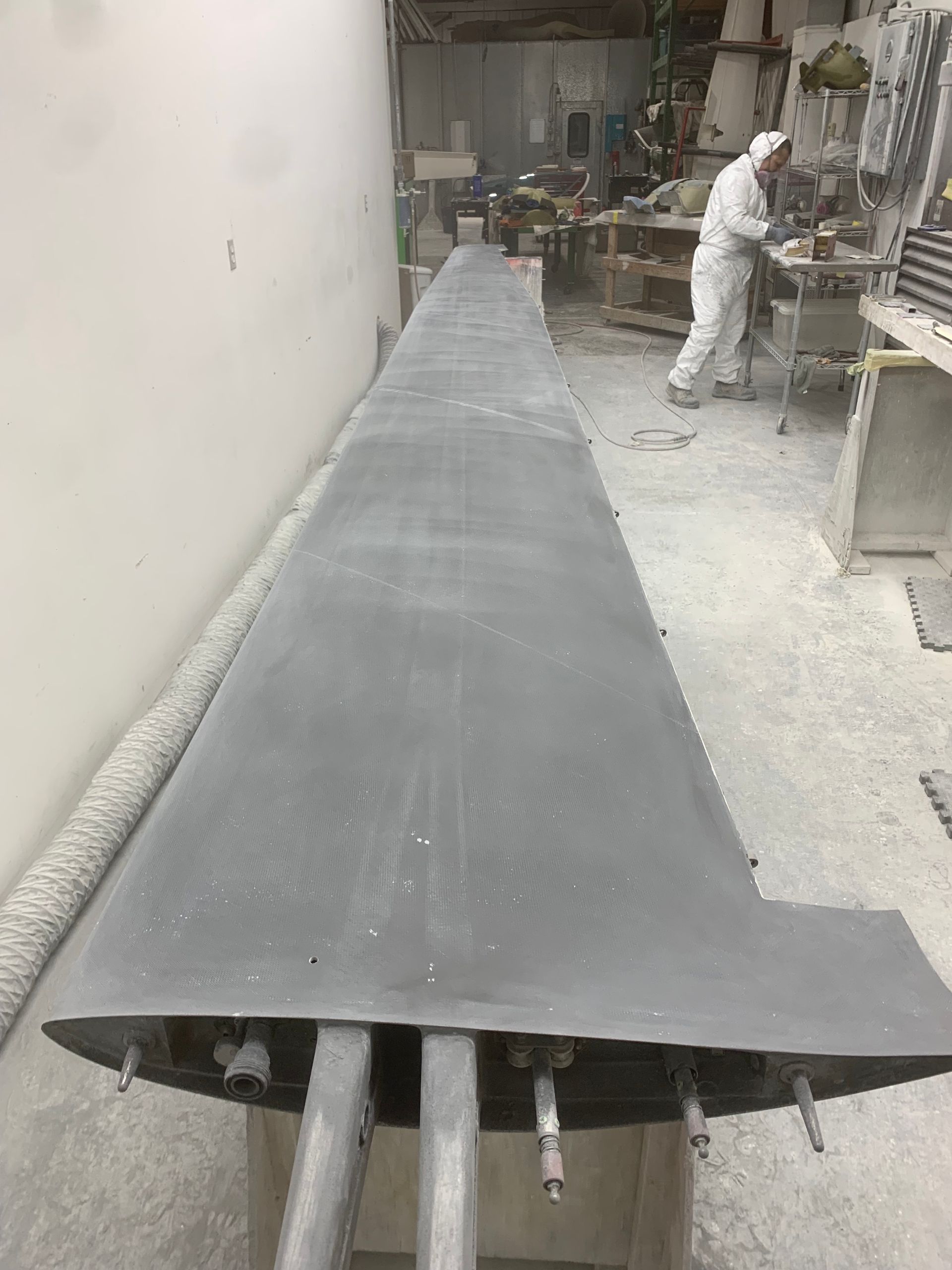 A man is working on a large piece of metal in a factory.