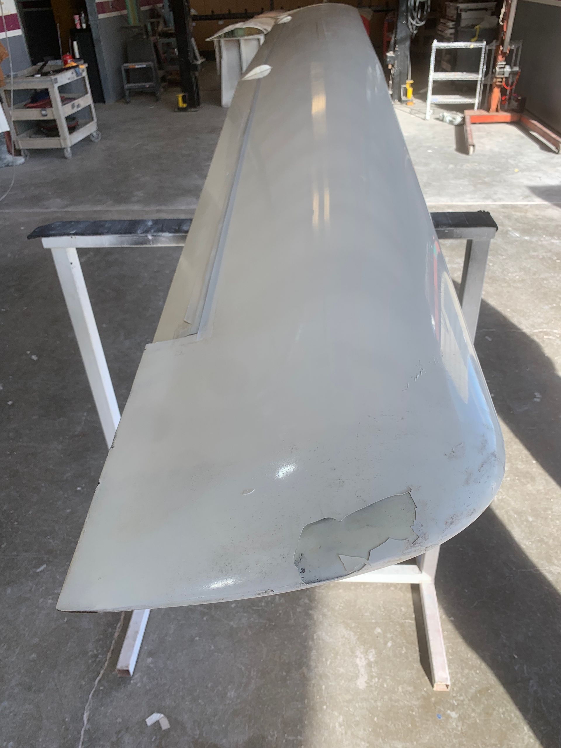 A large white piece of metal is sitting on a white stand.