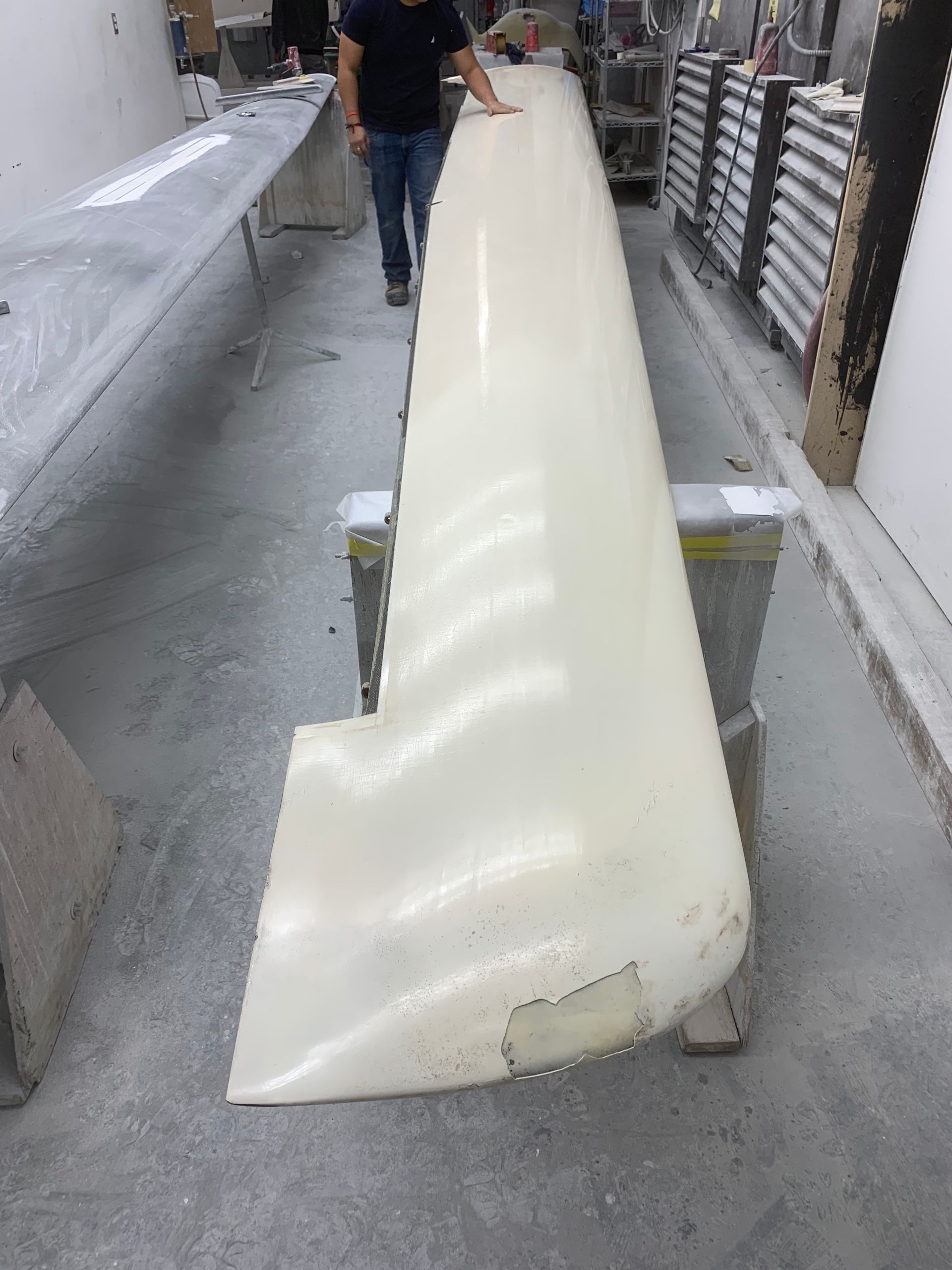 A man is standing next to a large white piece of plastic.