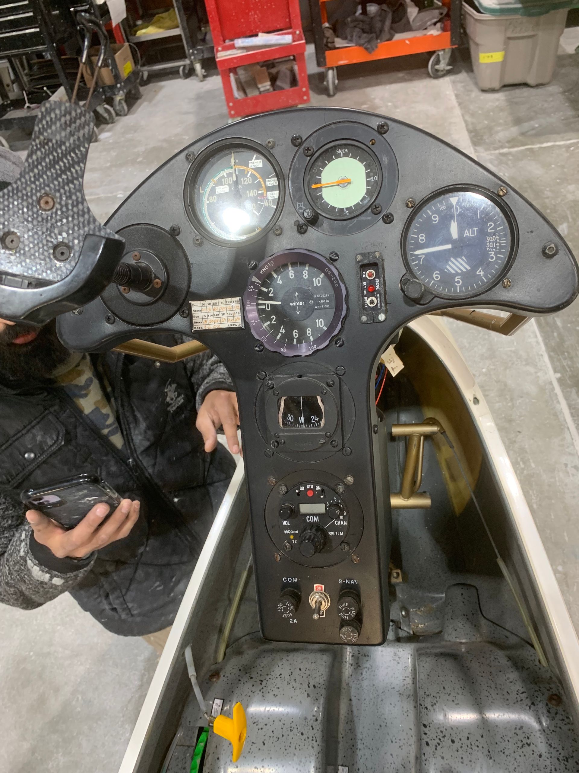 A man is sitting in the cockpit of an airplane holding a remote control.
