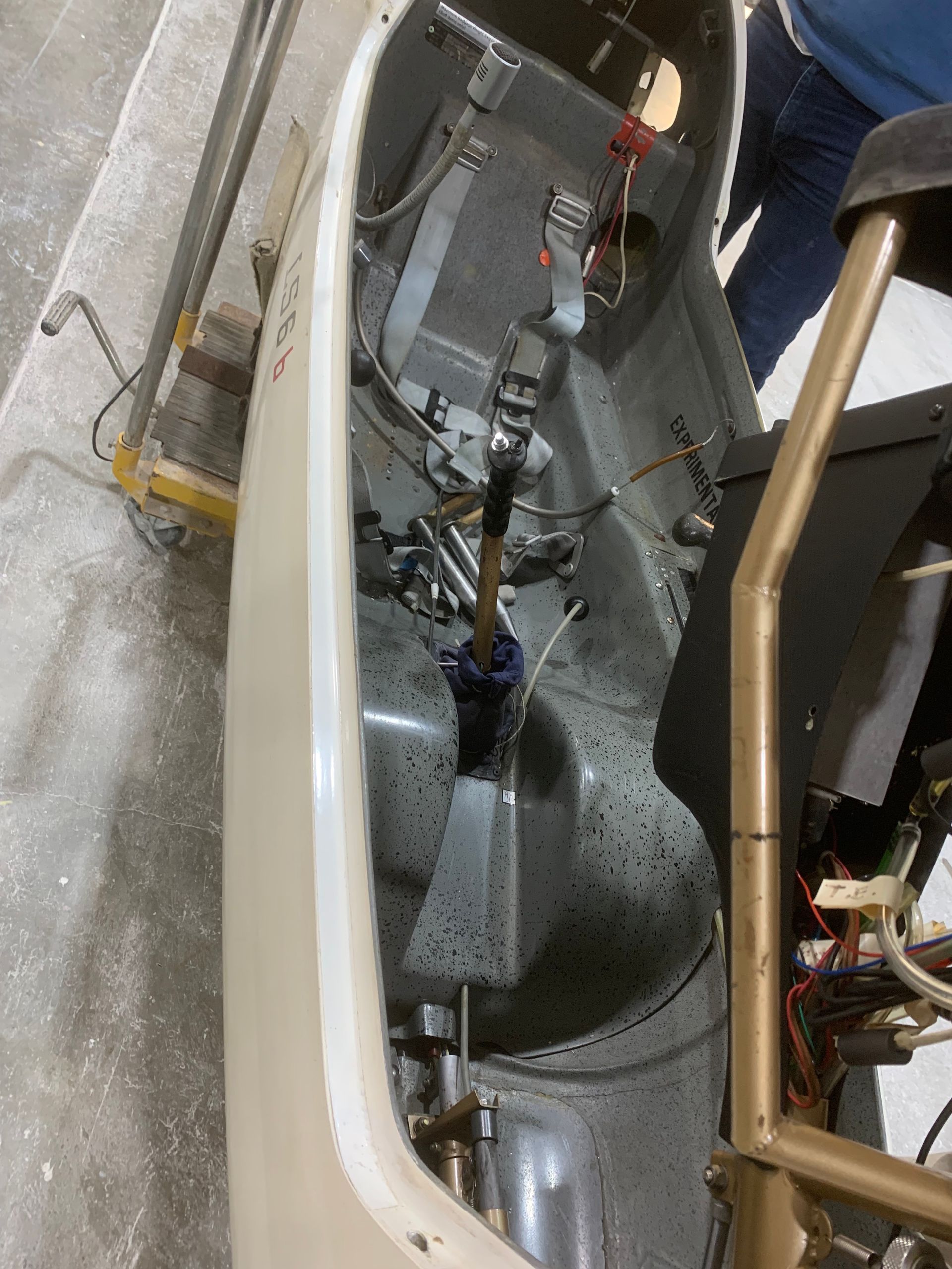 A person is standing next to a machine that is being worked on.