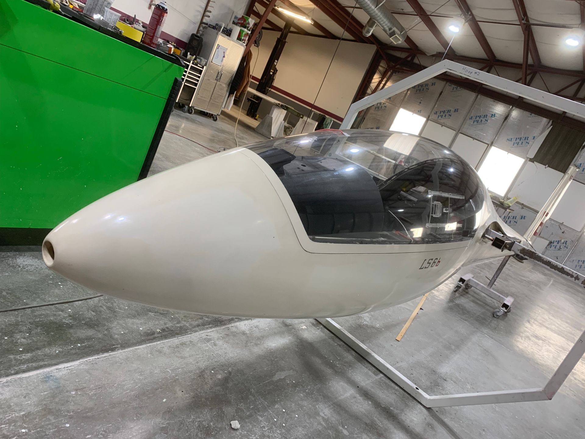 A small plane is sitting on the ground in a hangar.