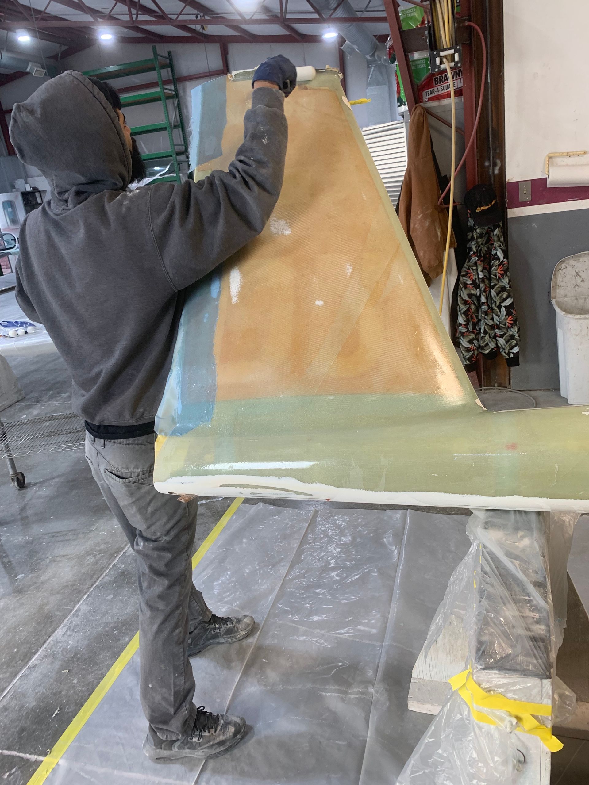 A man is carrying a large piece of wood in a room.