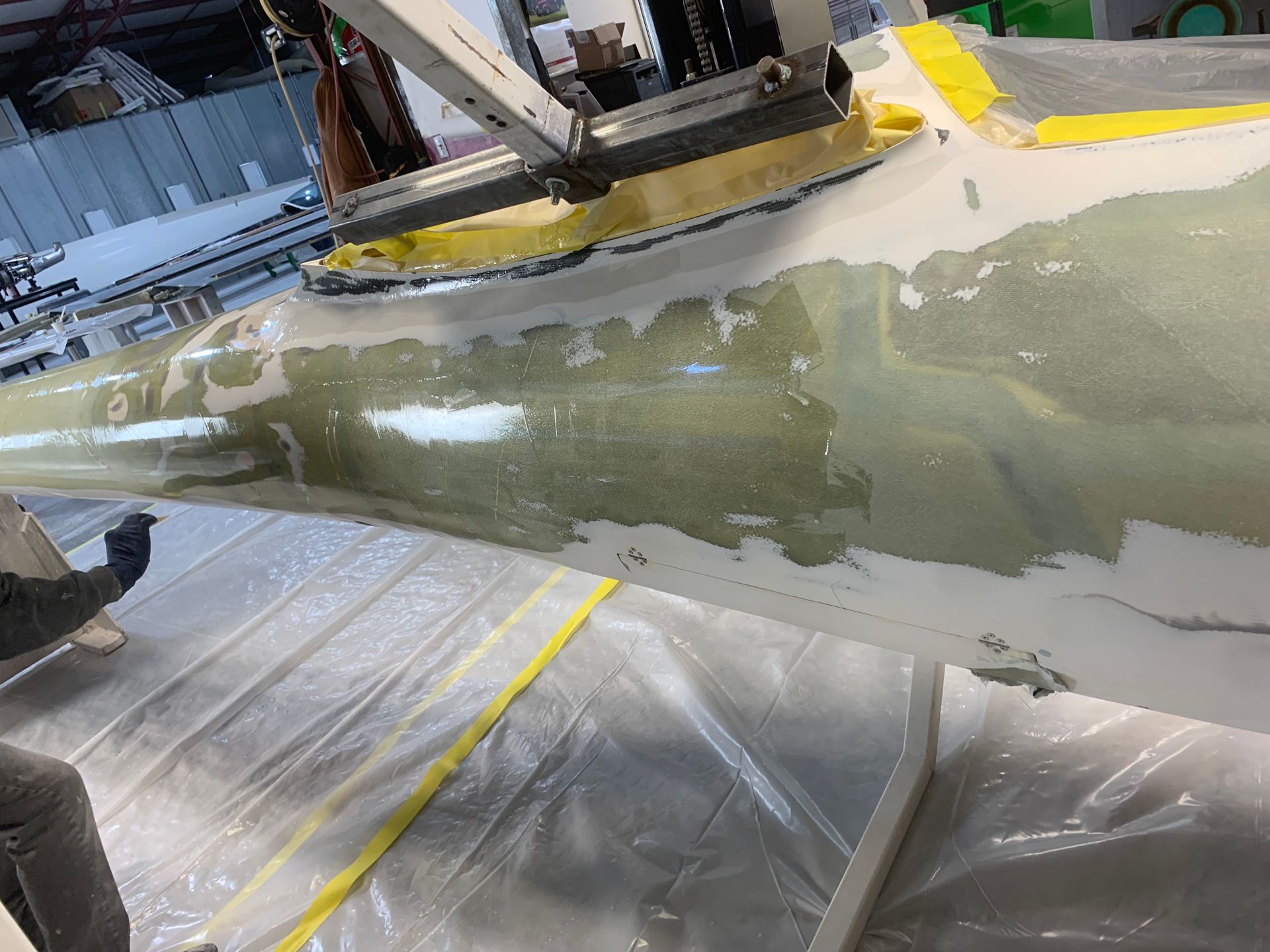 A person is working on a piece of plastic on a table.