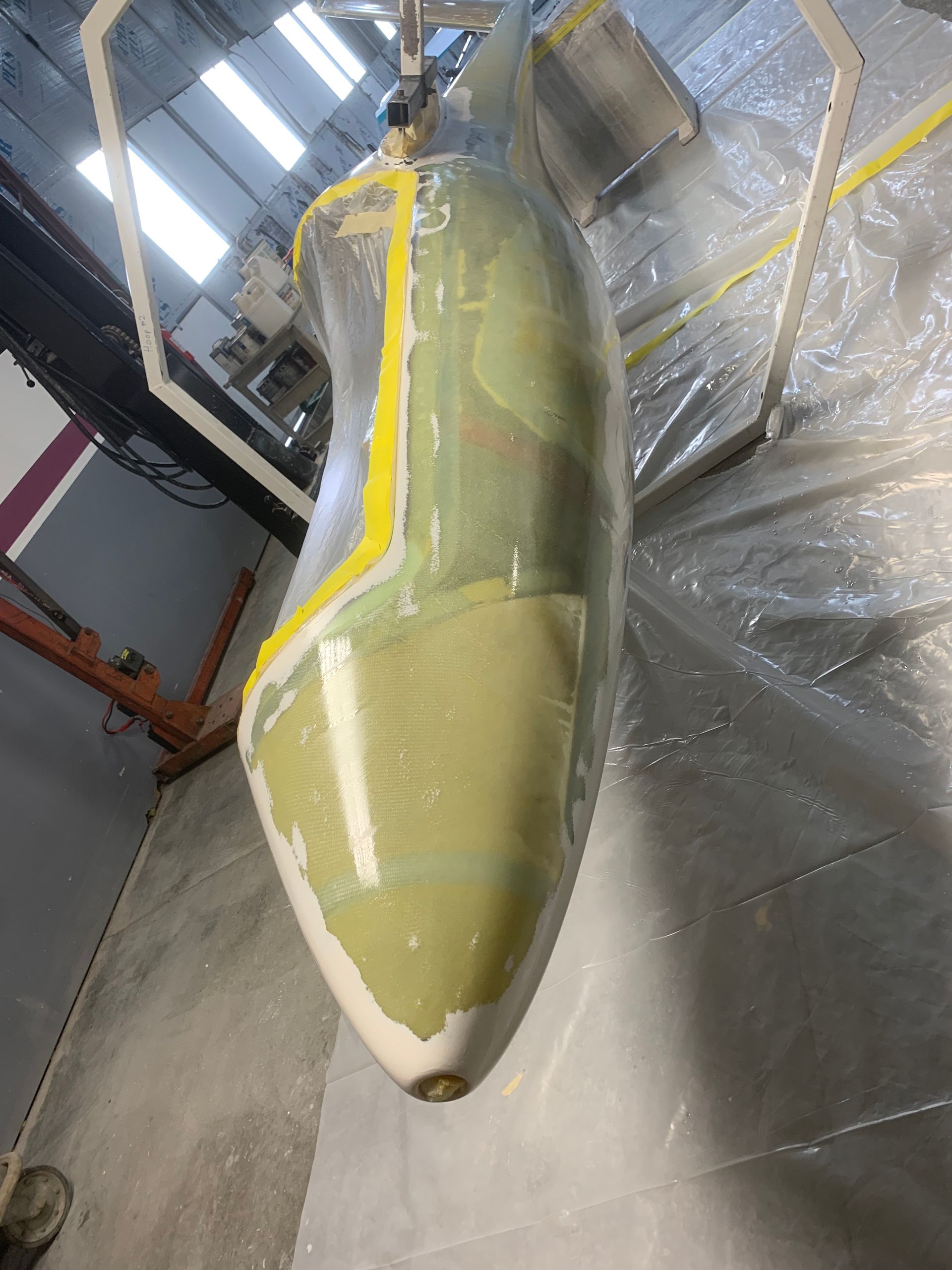 A plane is being painted in a garage.