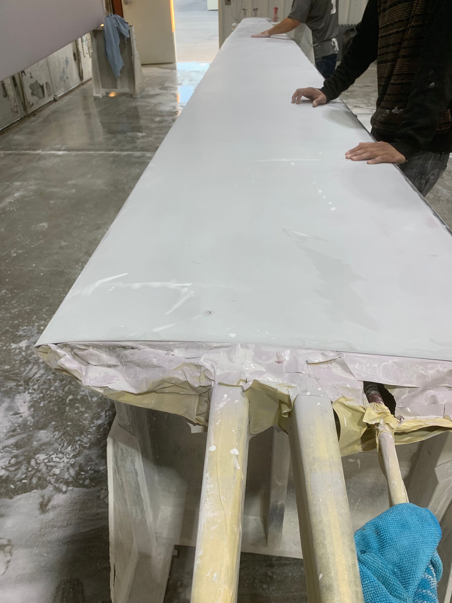 A person is standing next to a long white table.