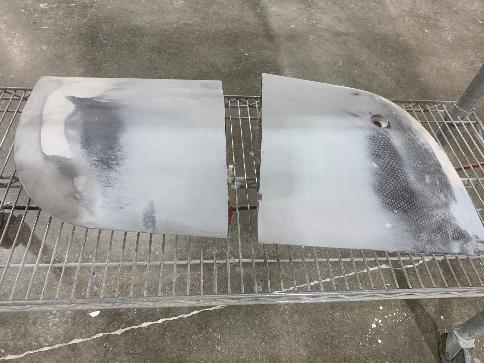 Two pieces of plastic are sitting on a metal shelf