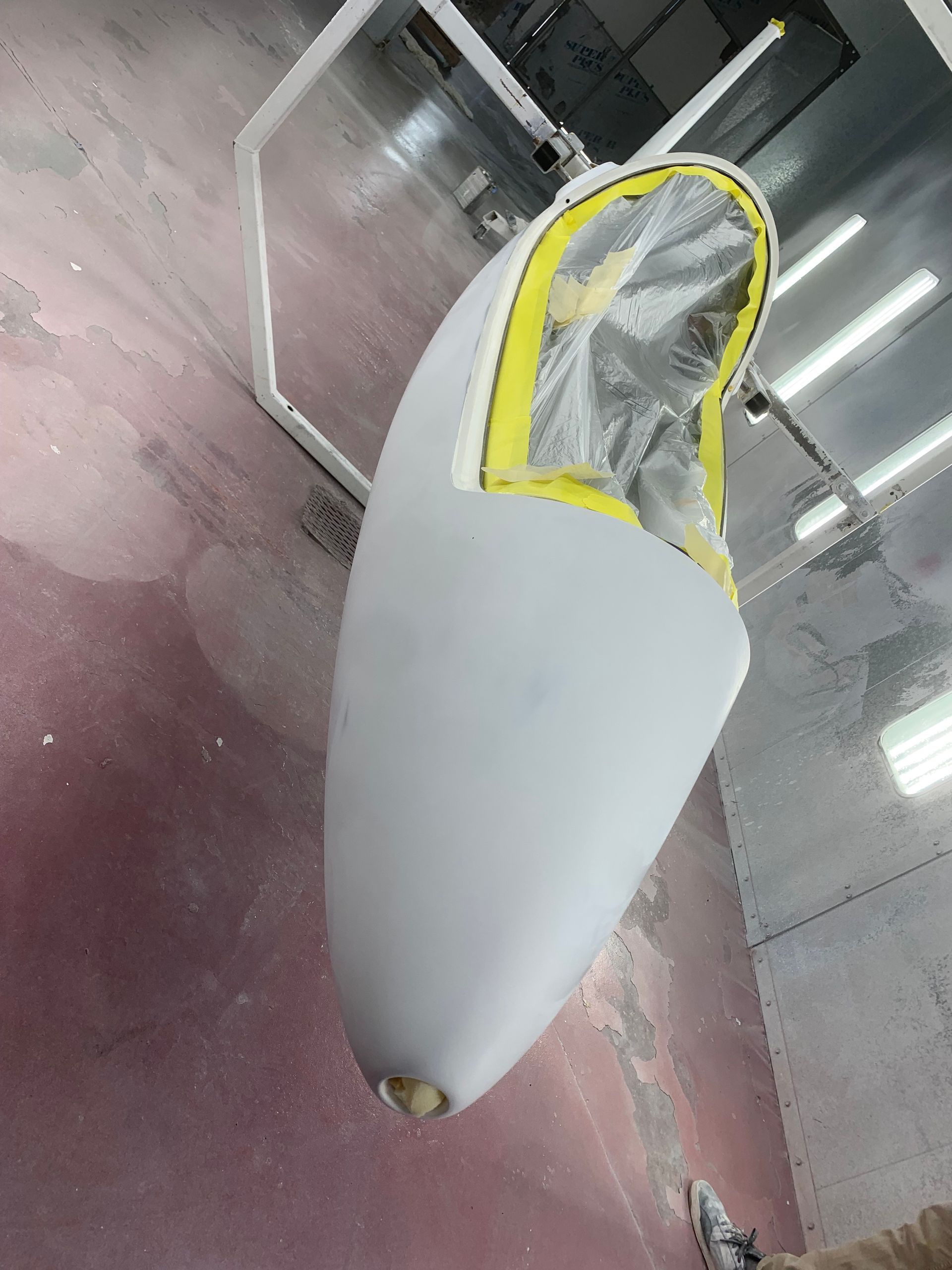 A white object with a yellow stripe on it is being painted