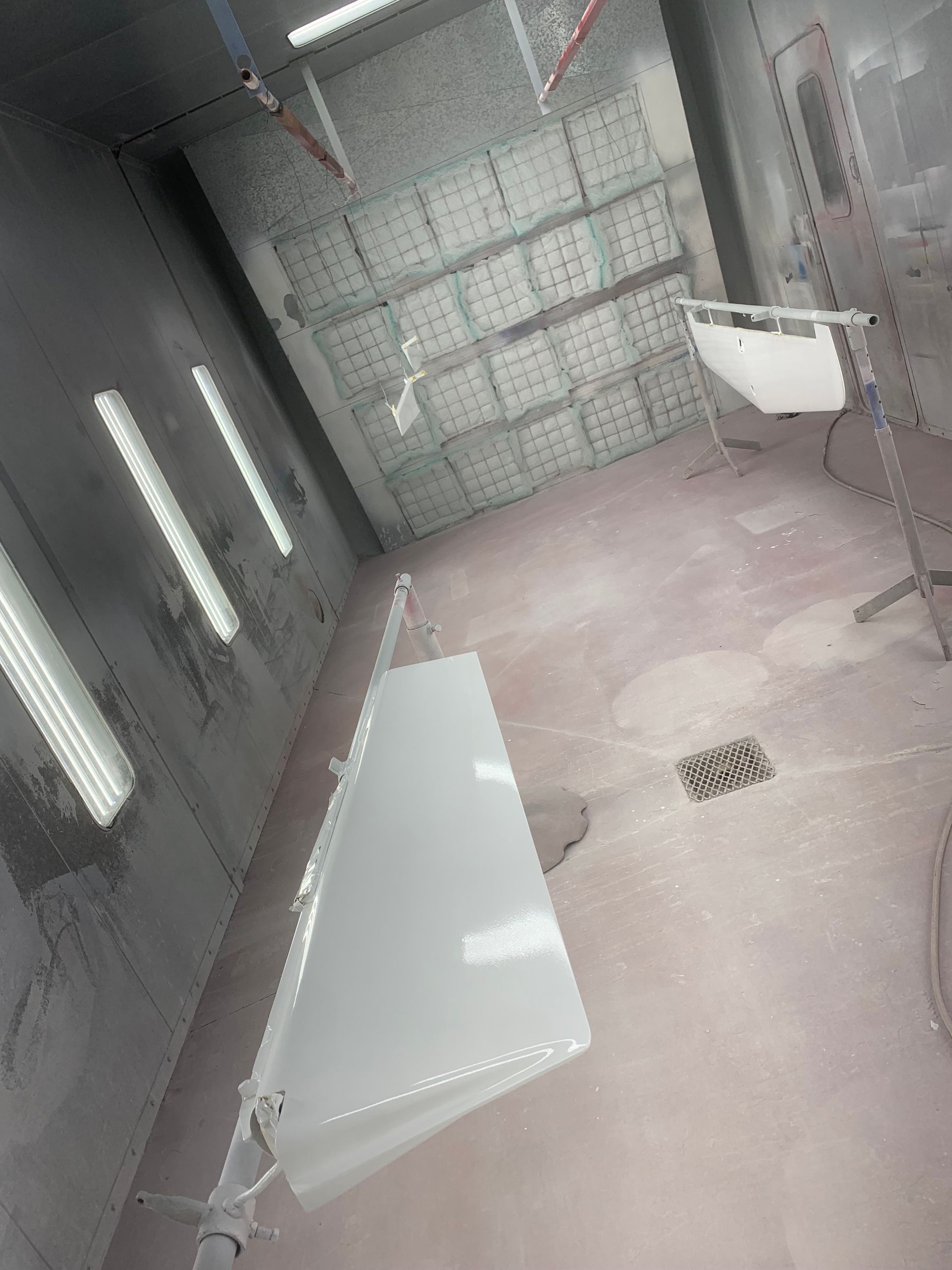 A white table is sitting in a paint booth.