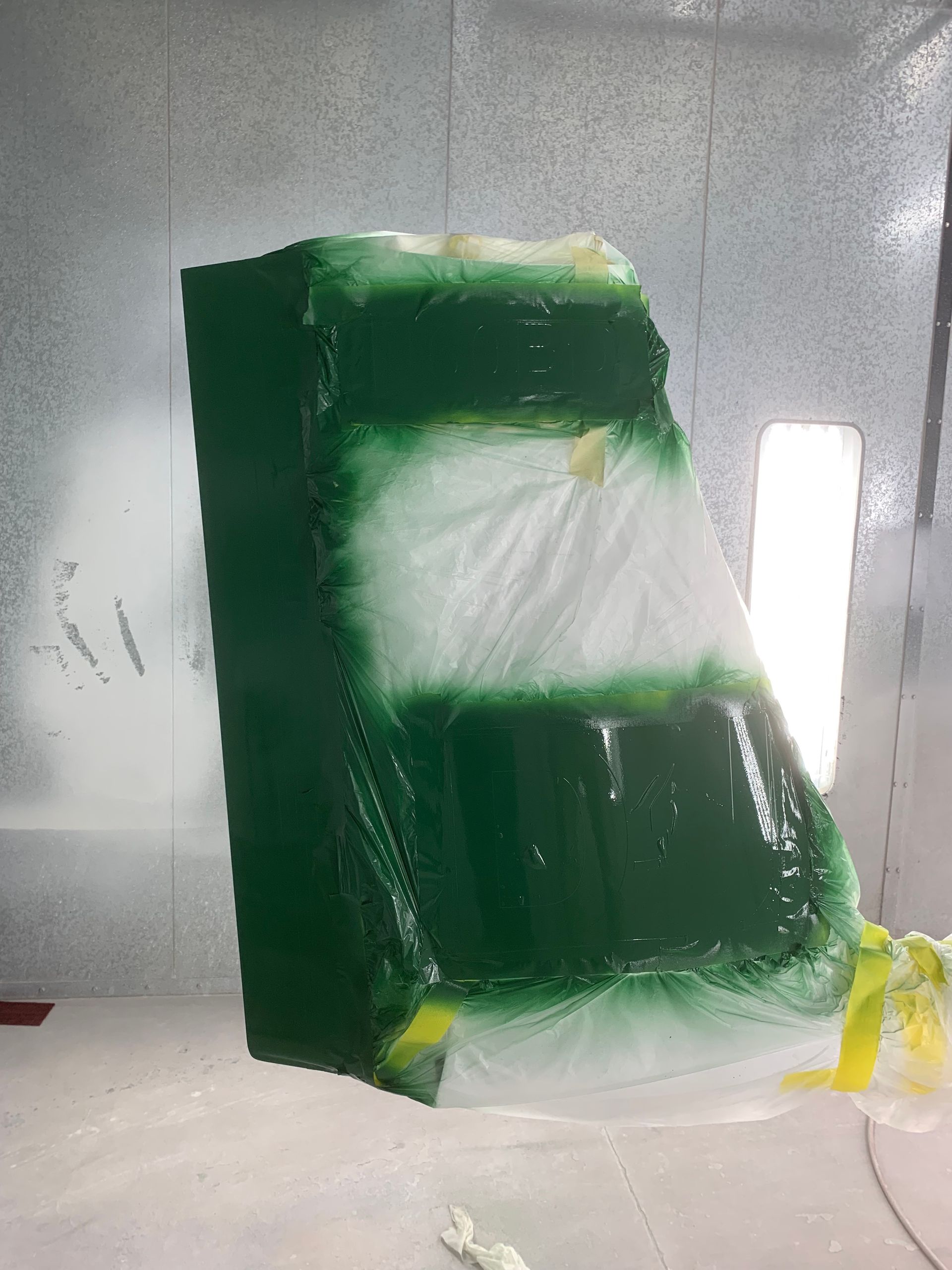 A green and white block is being painted in a room.