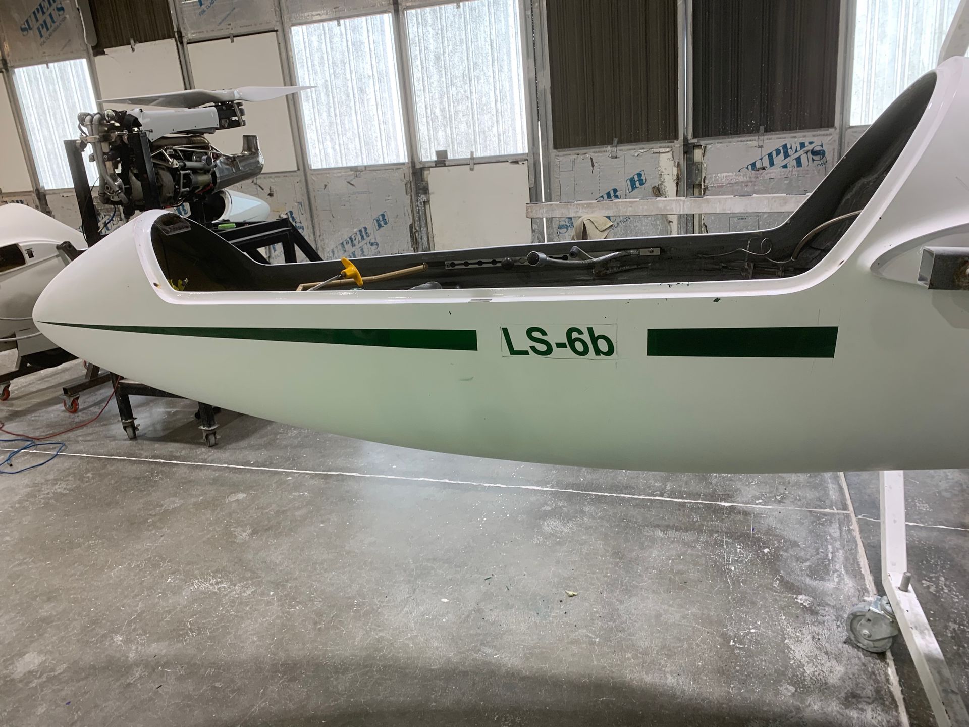 A small white plane is sitting in a hangar.