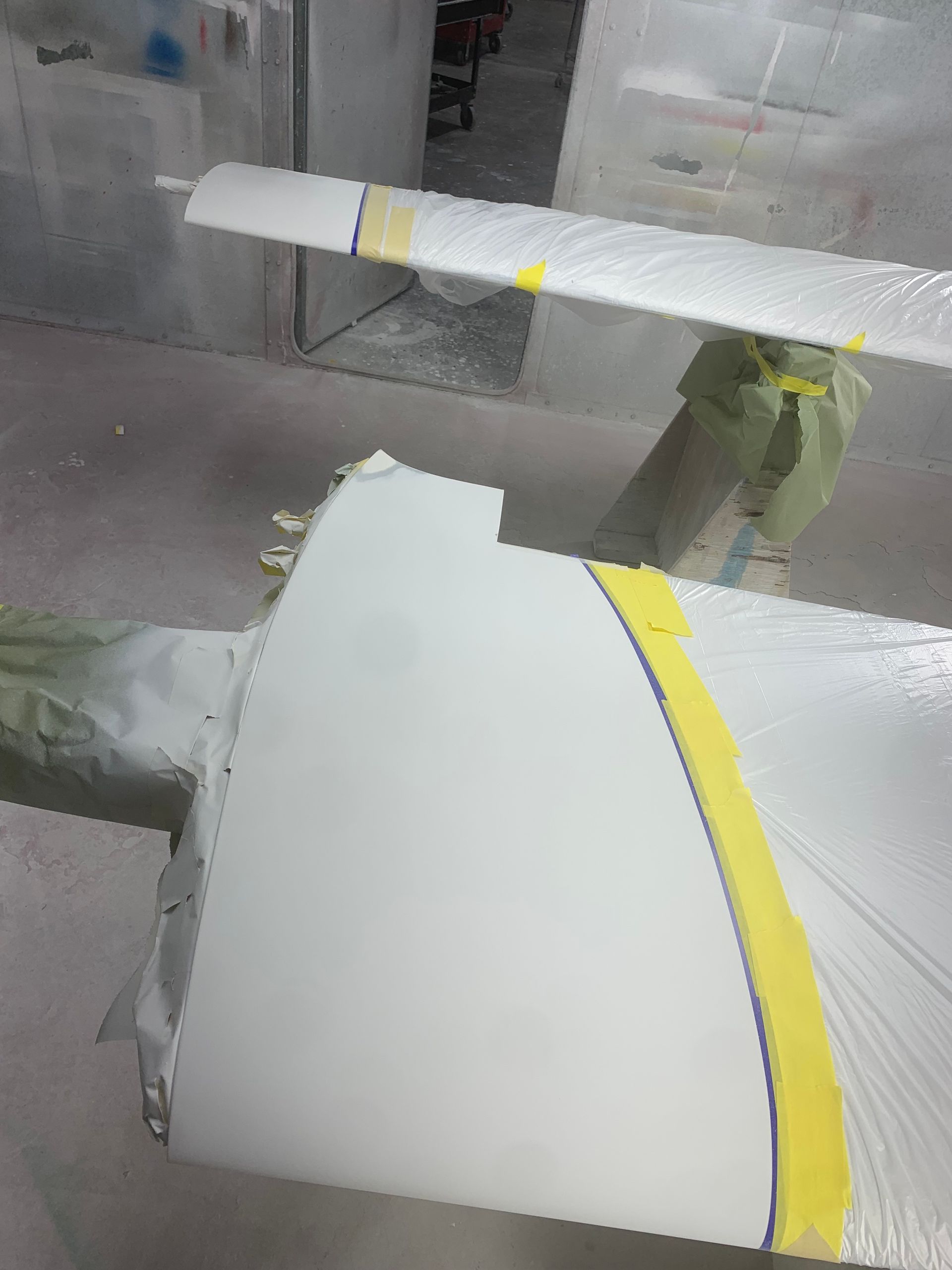 A white object with yellow tape on it is being painted