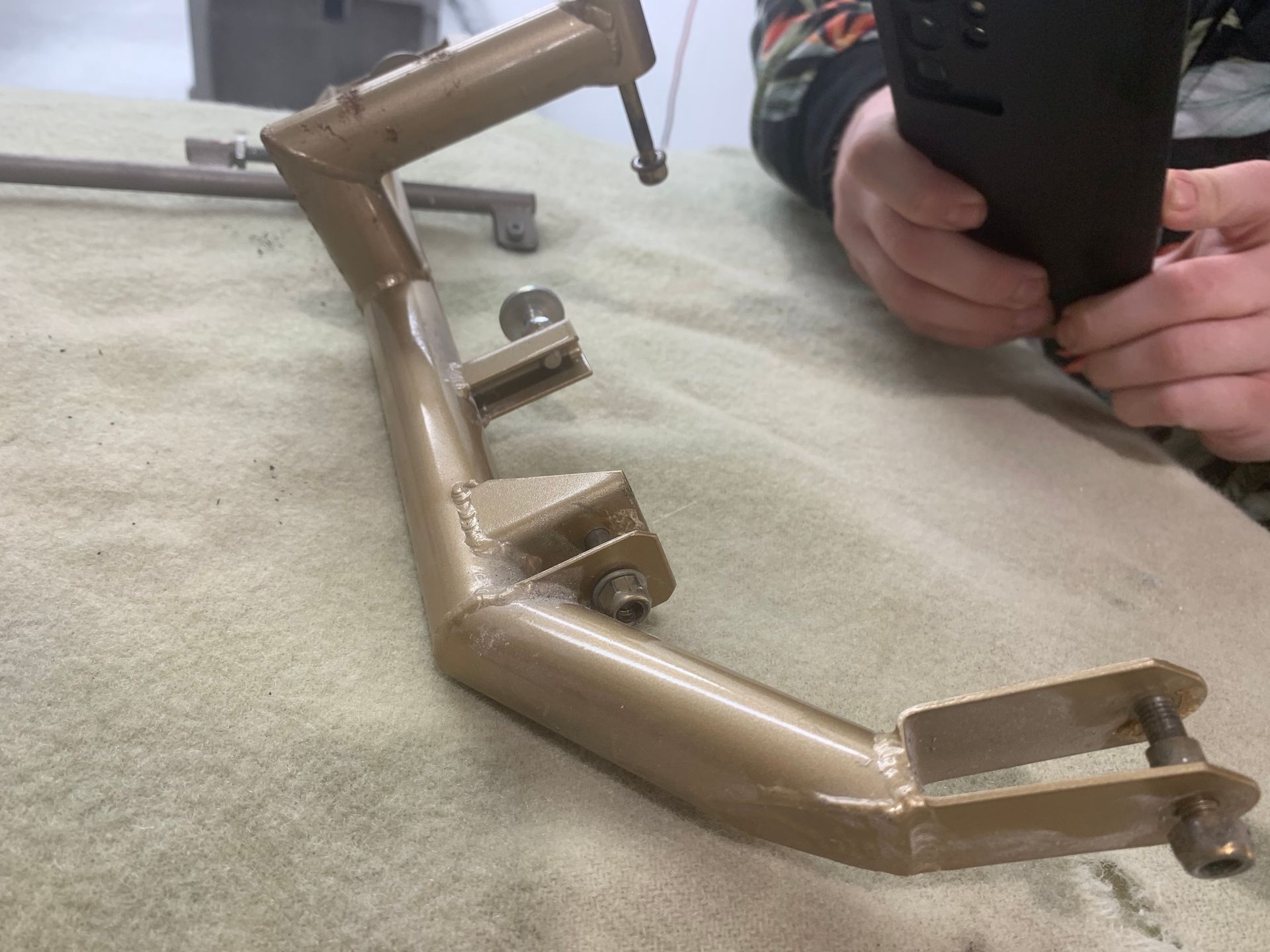 A person is working on a piece of metal on a table.