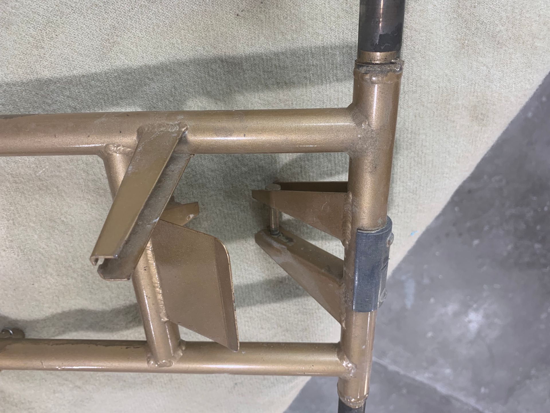 A metal frame is sitting on top of a concrete floor.