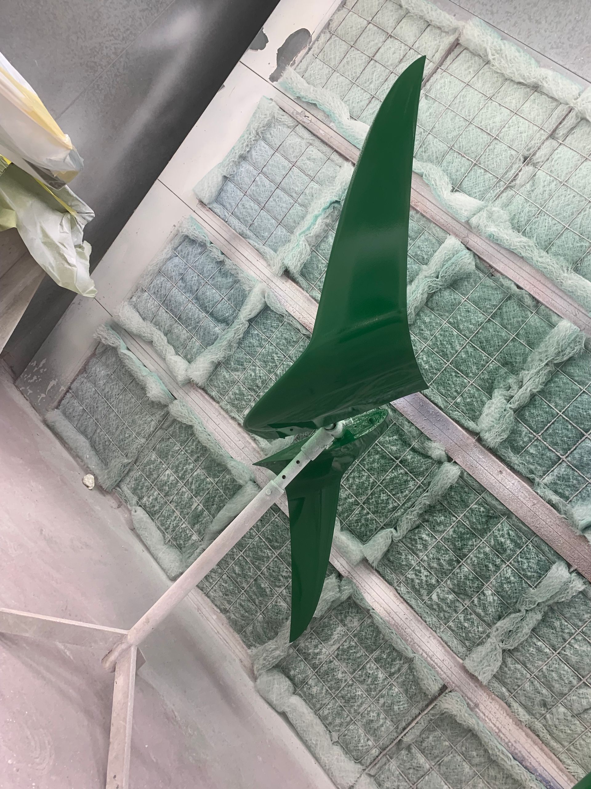 A green wind turbine is sitting on top of a table.