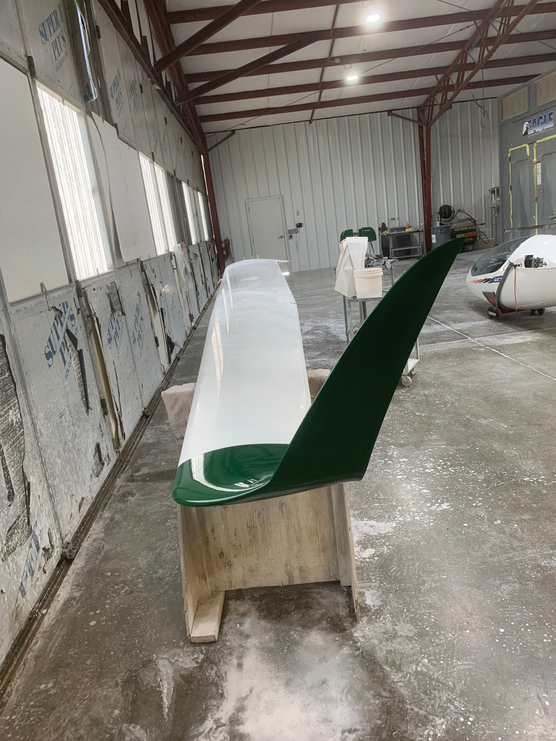 A green and white chair is sitting in a warehouse.