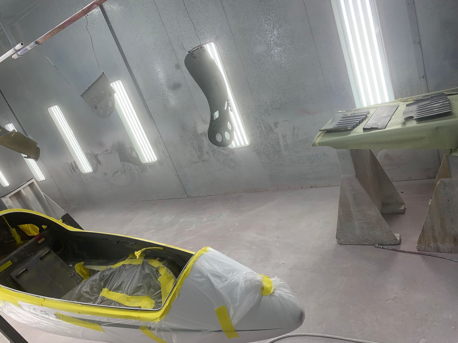 A motorcycle is being painted in a paint booth.