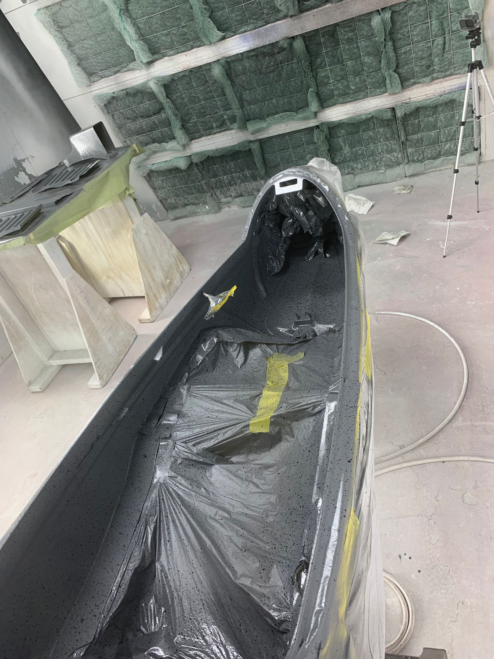 A boat is being painted in a paint booth.