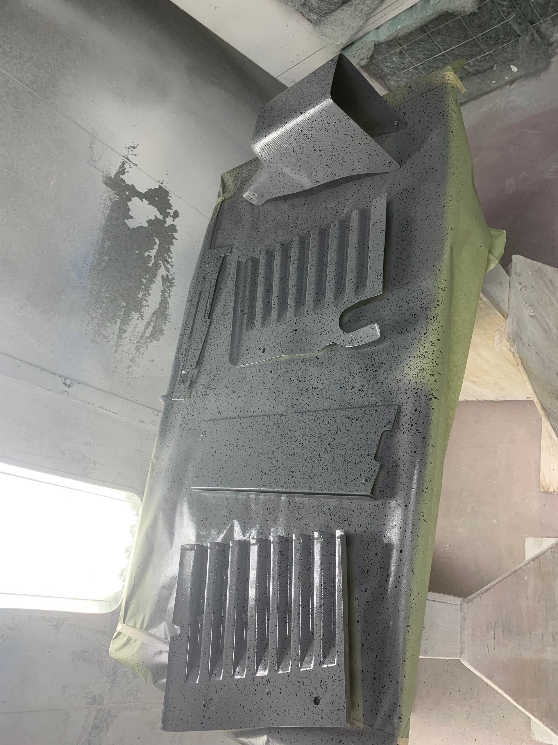 A piece of metal is covered in spray paint.